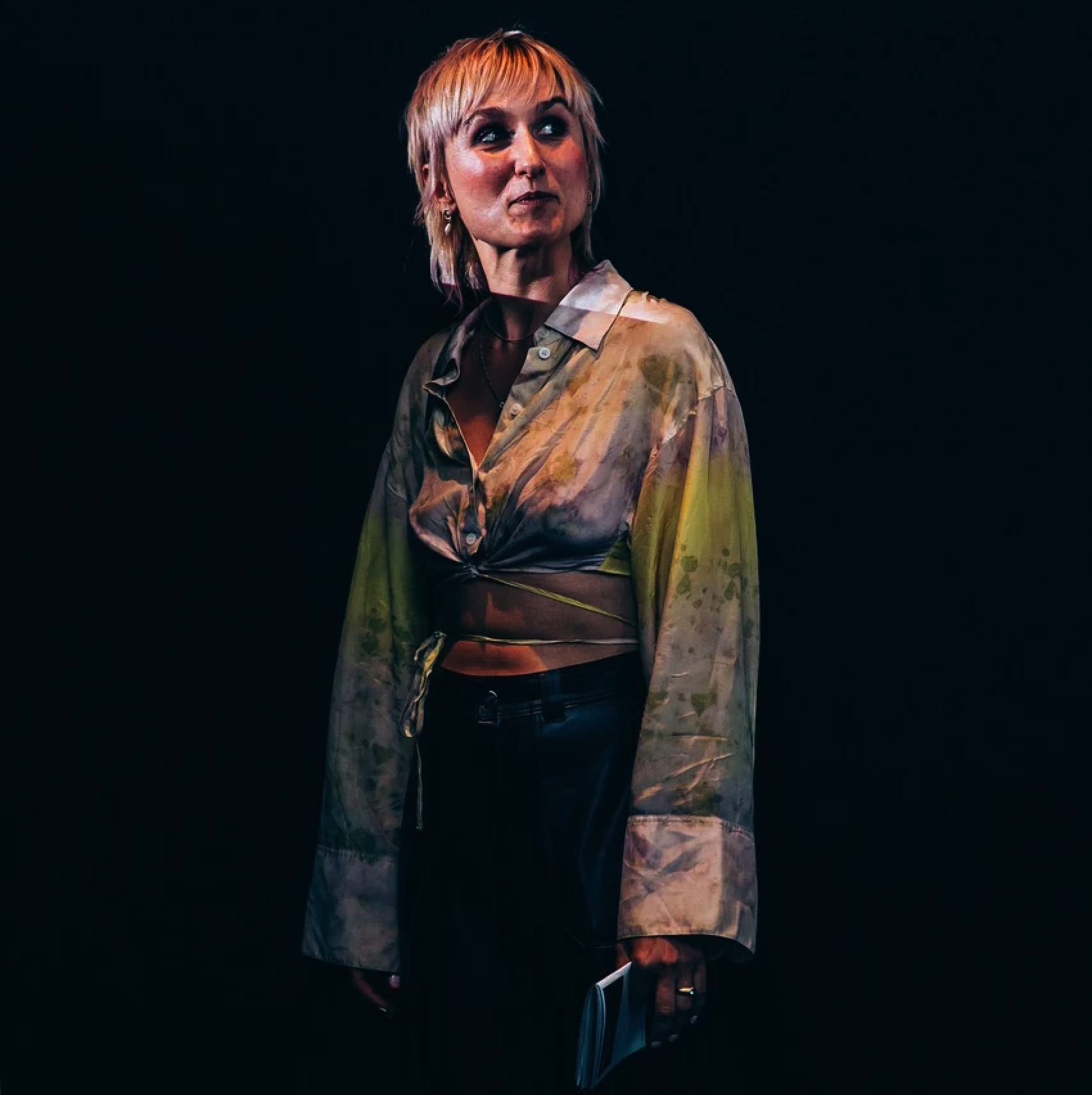 Maxi Meissner at SMUT FEST at De Studio in Antwerp, wearing a colorful, patterned shirt tied at the waist, standing in a cinema room to introduce her film programme.