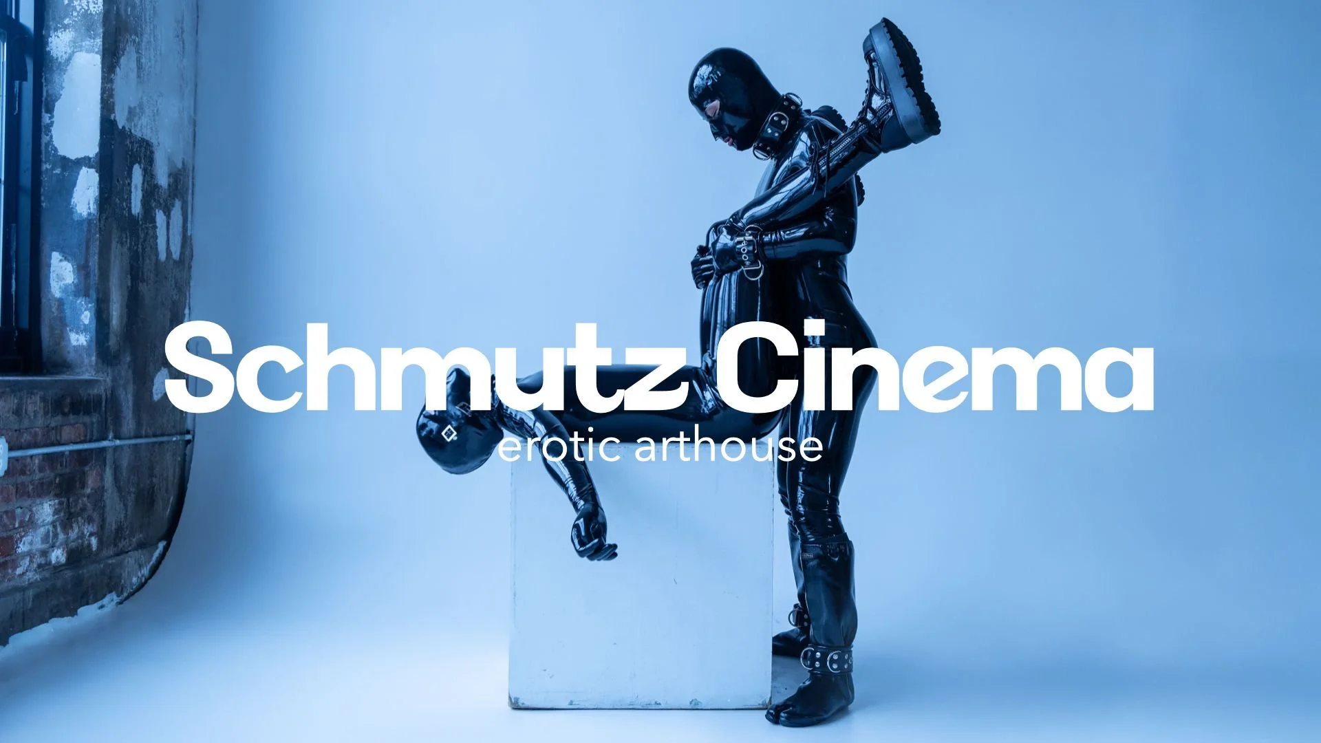 Two individuals in shiny black latex suits and helmets, with one standing and the other in a handstand position, against a blue background with the text "Schmutz Cinema" and "erotic arthouse" overlayed.
