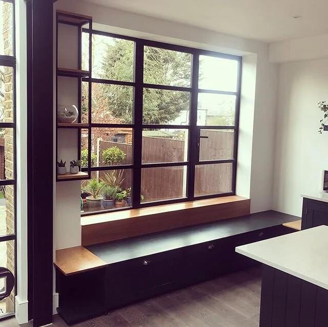 Window seat into side tables. 2 drawers, 1 closed corner cupboard and 2 lower open cook book shelves. 1 floating shelf unit for plants. Cherry wood, painted ply and black powder coated steel. #bespoke #craft #cherrywood #london #e17 #carpentry #kitch
