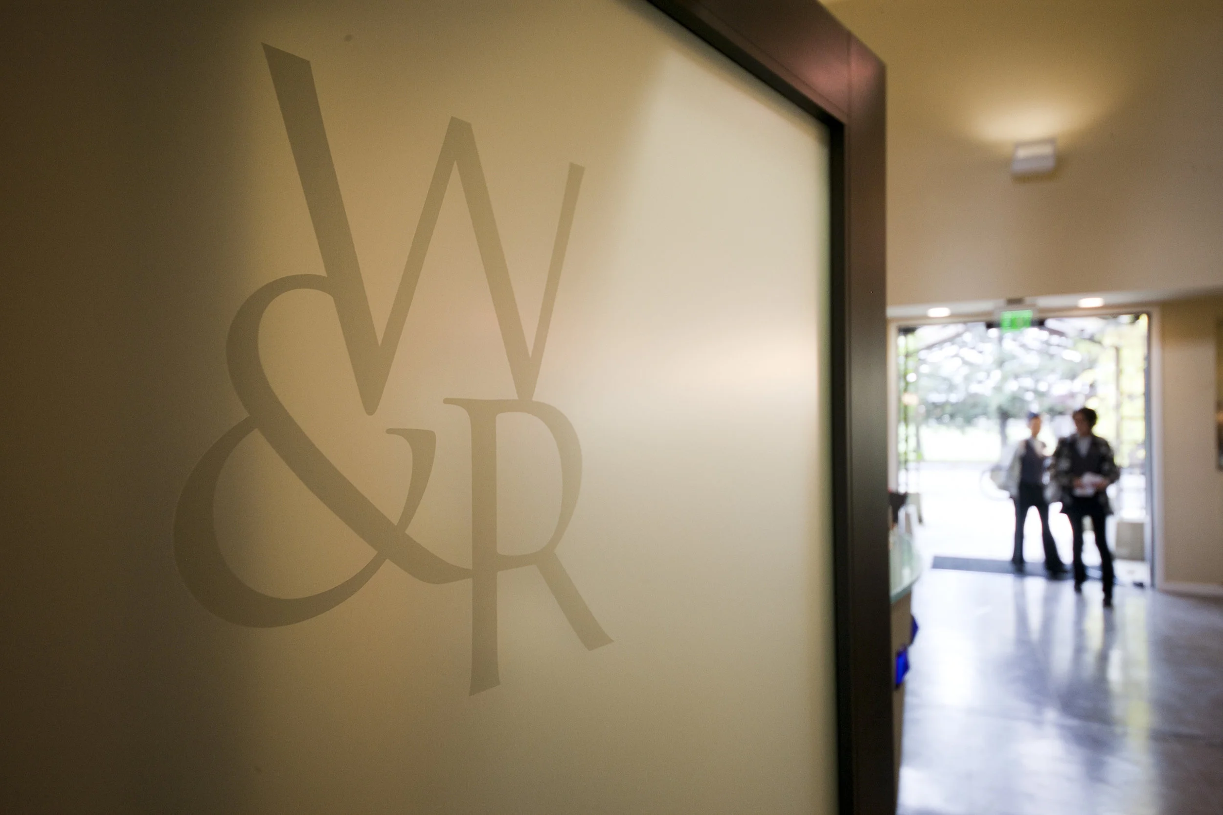 photo of the wine and roses spa logo with guests in background