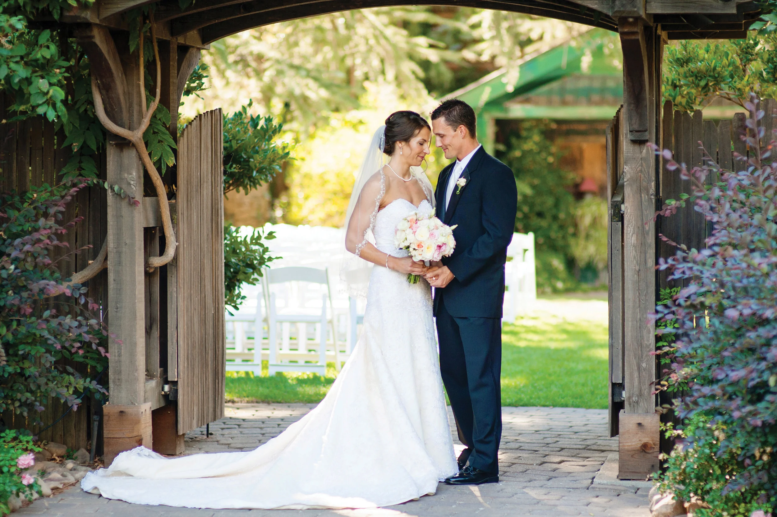 photo of the bride and groom in front of the wedding garden gate