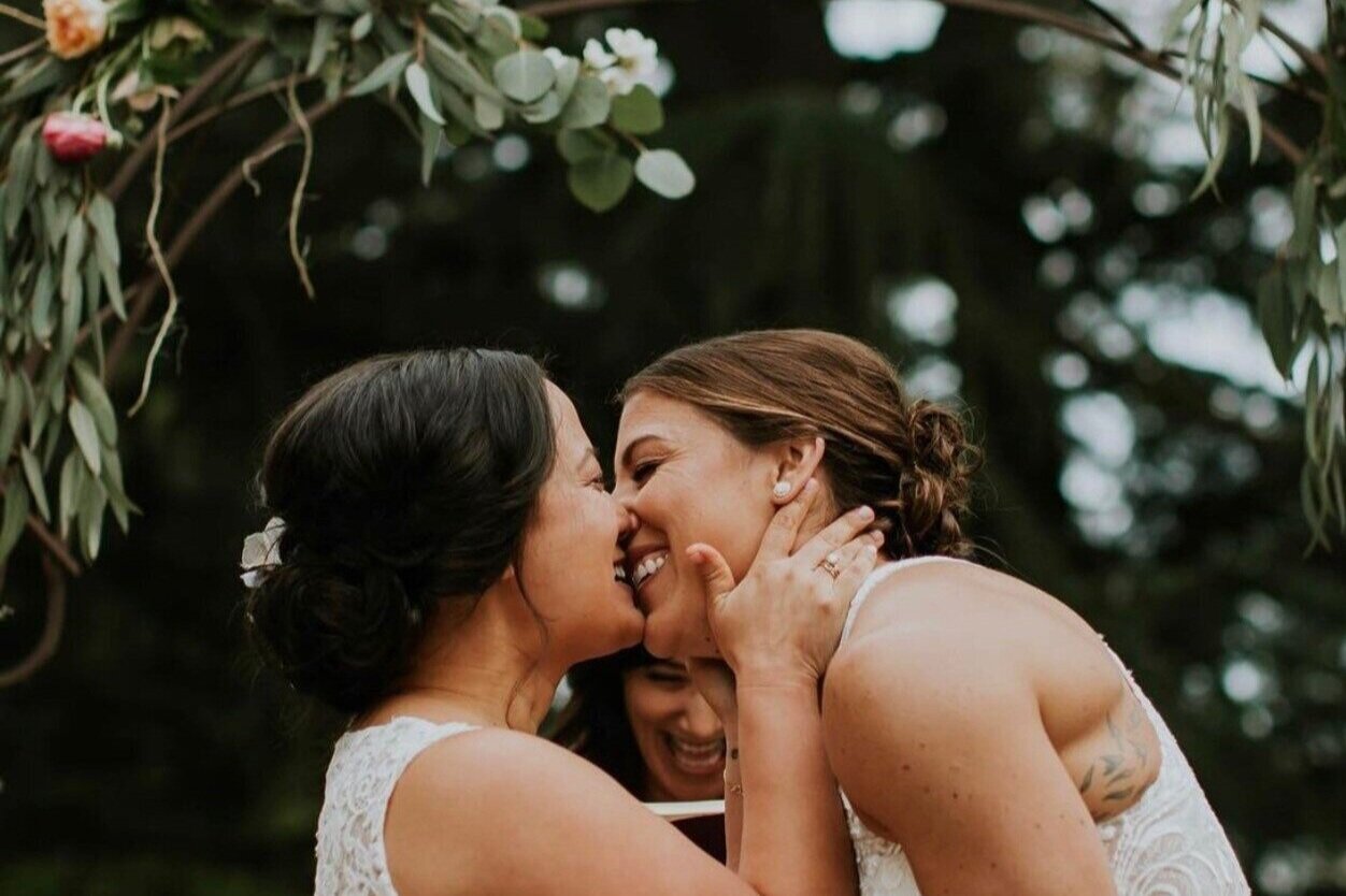 Photo of two brides kissing