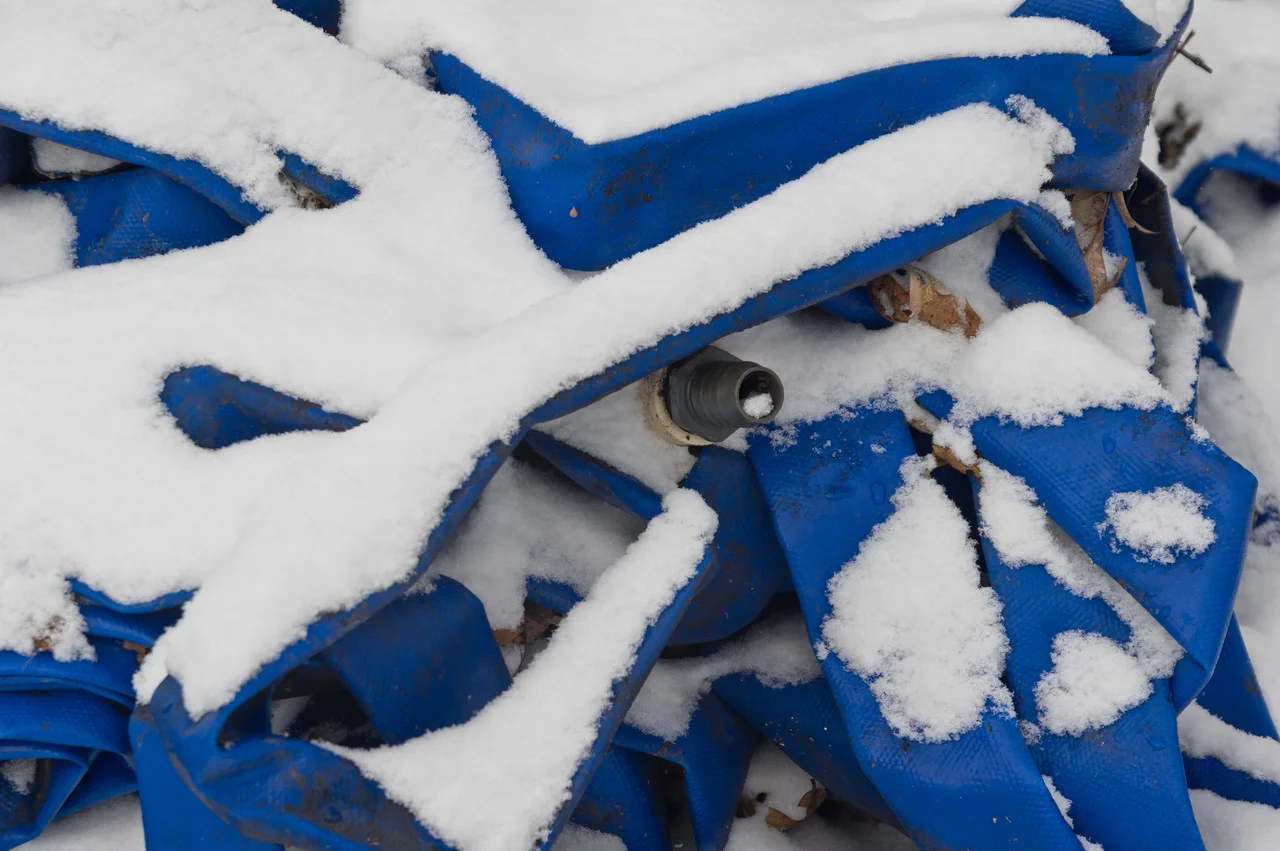 irrigation lines piled in the snow, photo by Adam Ford