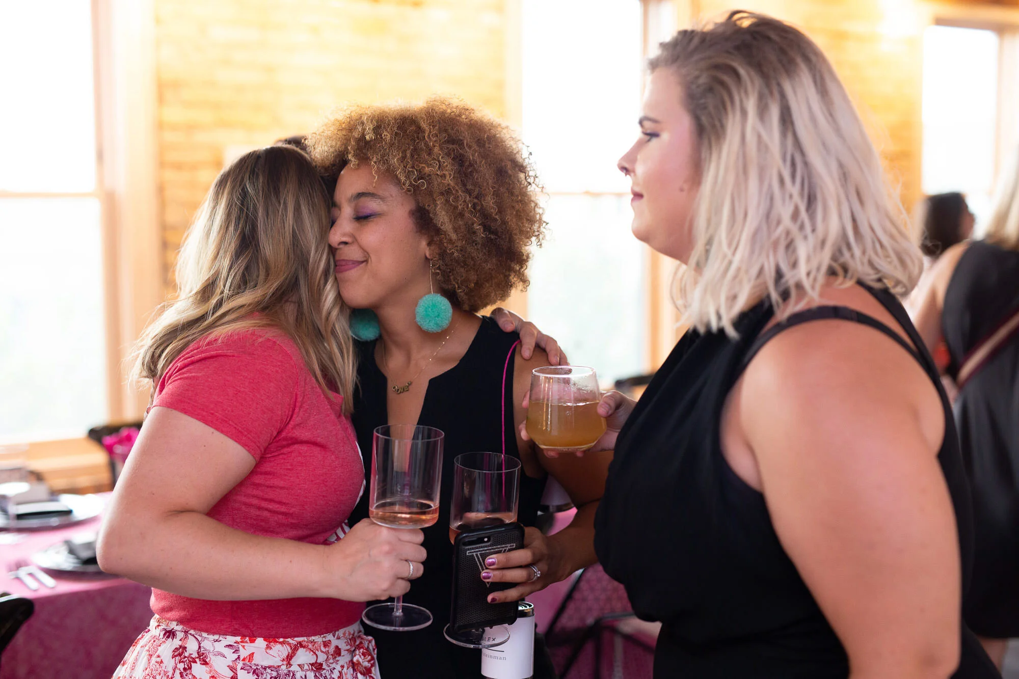  guests mingle and hug at womxn’s event 