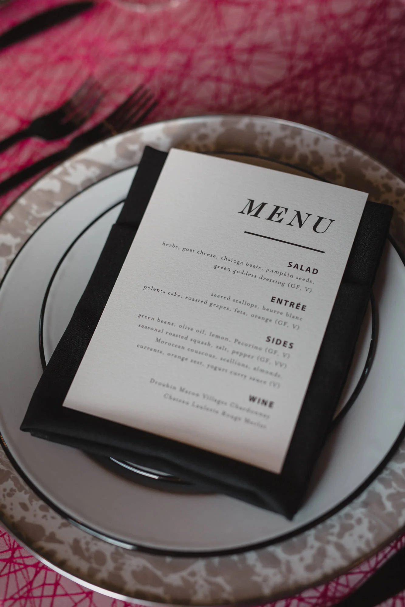  black and white menu on plates, chargers and pink table cloth 