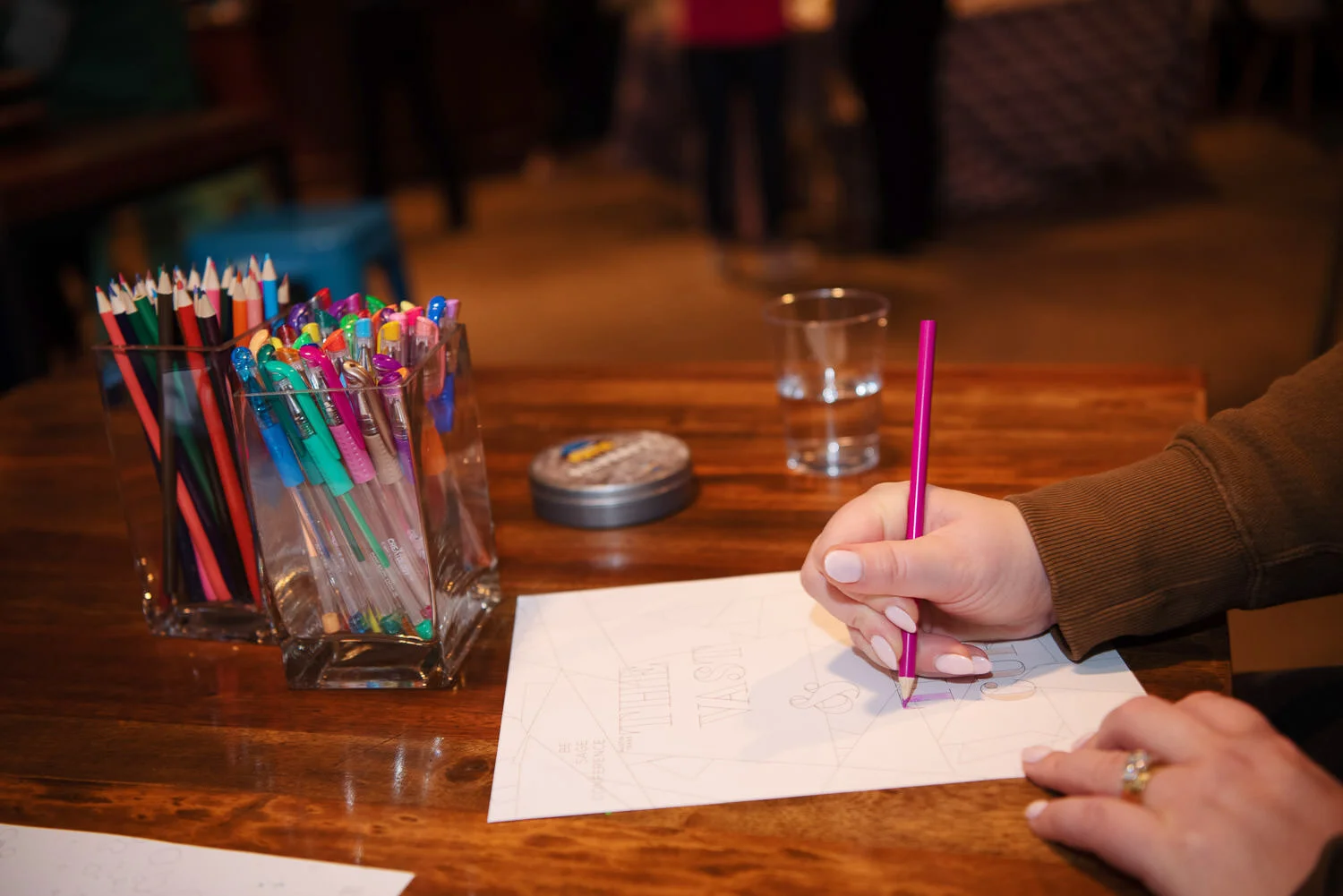  conference attendee writes a note with colorful pencils 