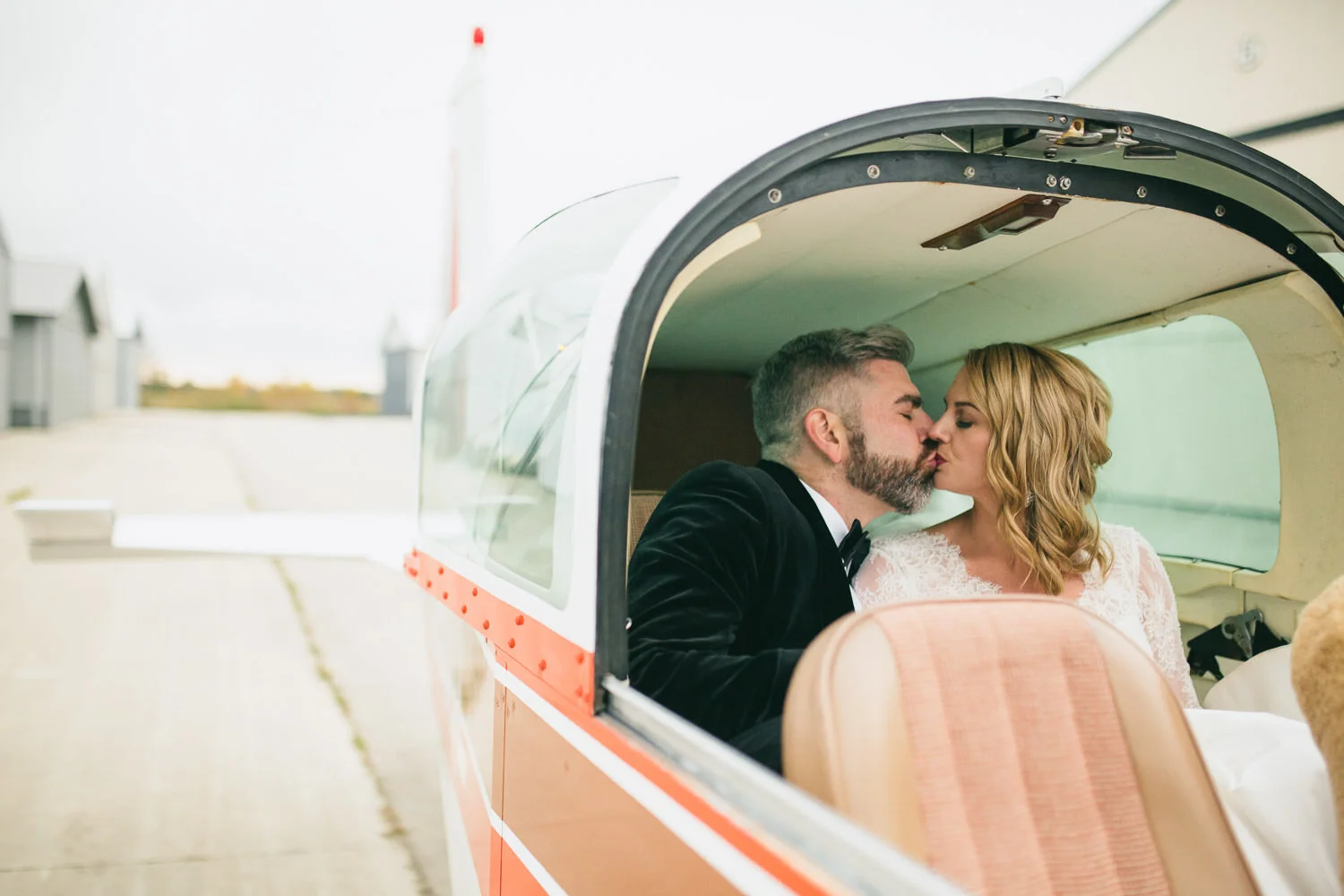  bride and groom kissing in red and white airplane 
