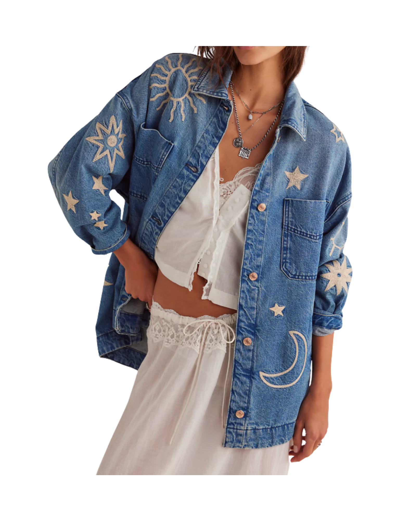 Person wearing a blue denim jacket with celestial embroidery, a white lace top, and a flowing white skirt with lace details.