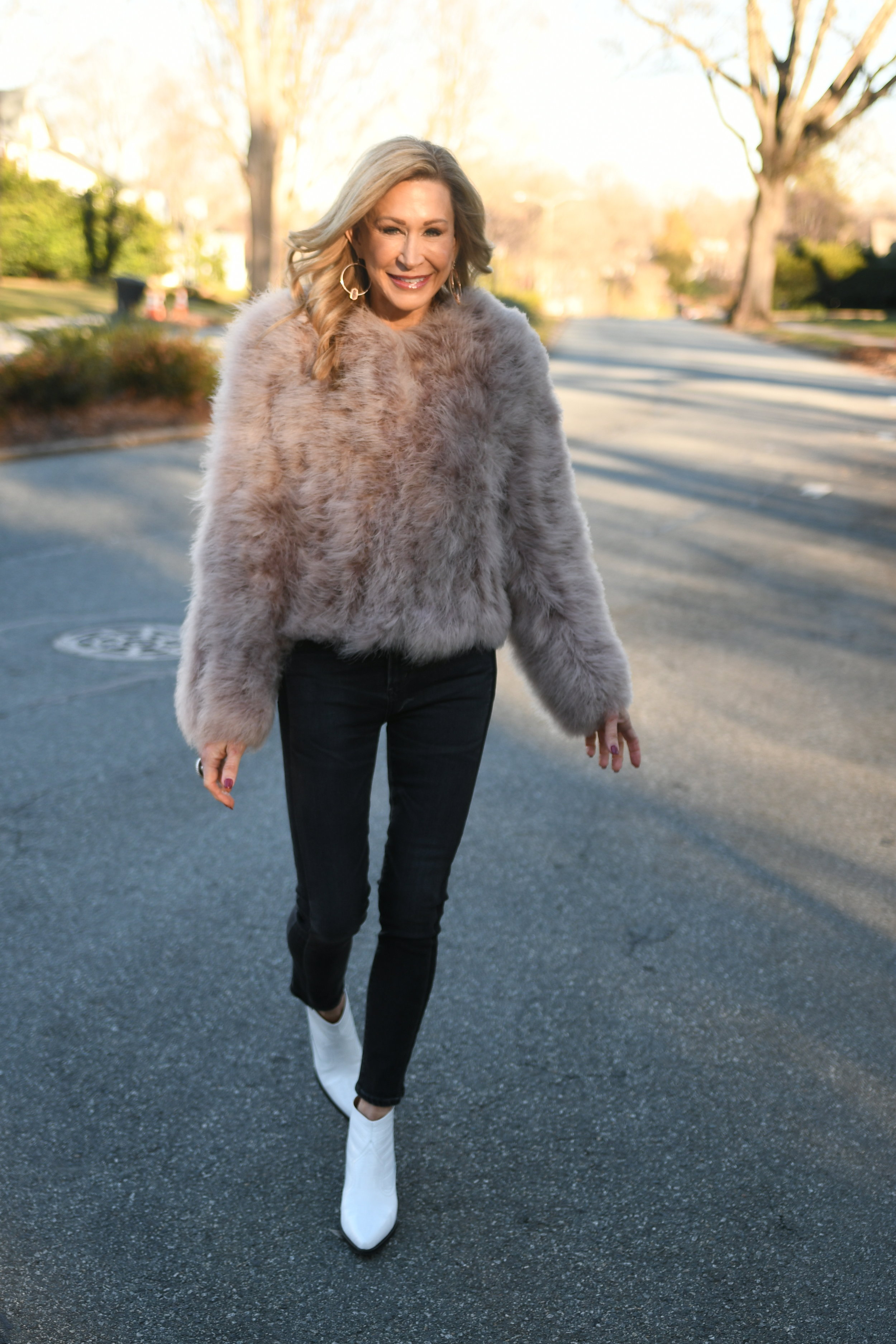 Pink fur coat with black jeans and white cowboy booties