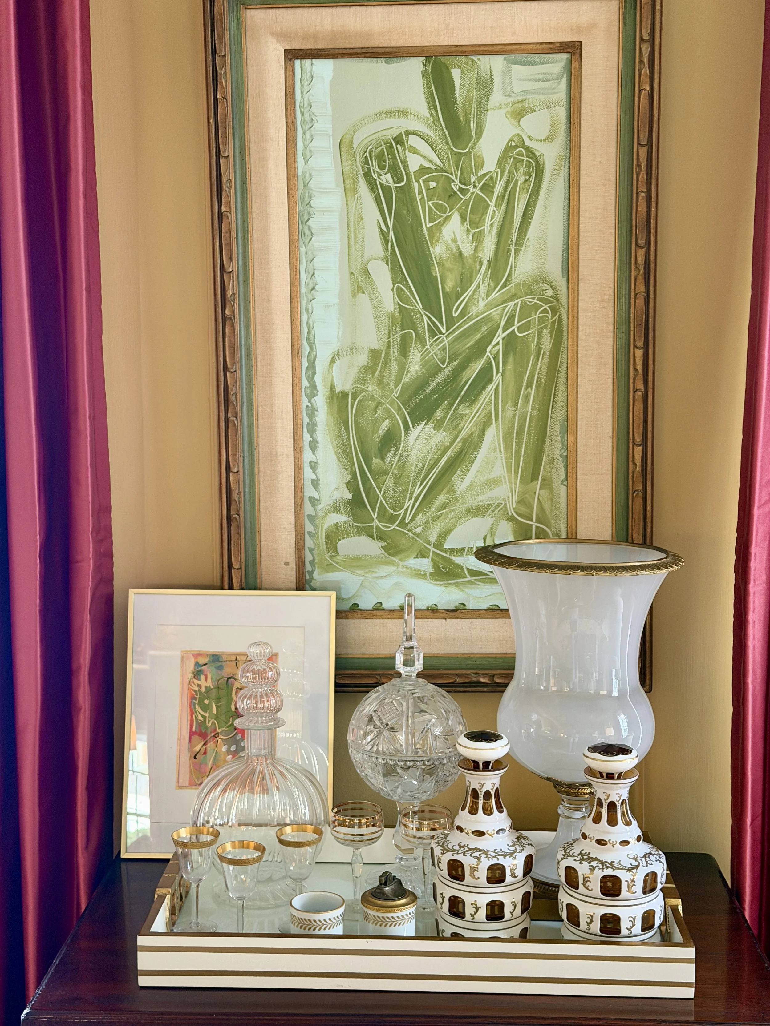   Lots of stories on this chest…The decanter to the left was given to me by a friend…she got it in Italy and brought it back for me. The little Limoge cigarette holder and lighter were also a gift.  The two vintage art deco decanters came from my decorator.  The little glasses  came from an antique store (sadly I’ve broken two) as did the cut glass candy dish.  The large piece of art in the background came from Lisa Johnson Co. in Greensboro NC and the smaller piece was painted by my neighbor who is an artist.  I just keep layering things!  