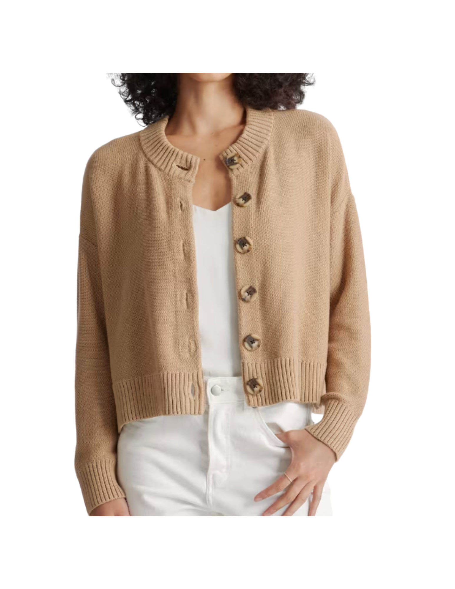 Woman wearing a beige cardigan over a white top with white pants.