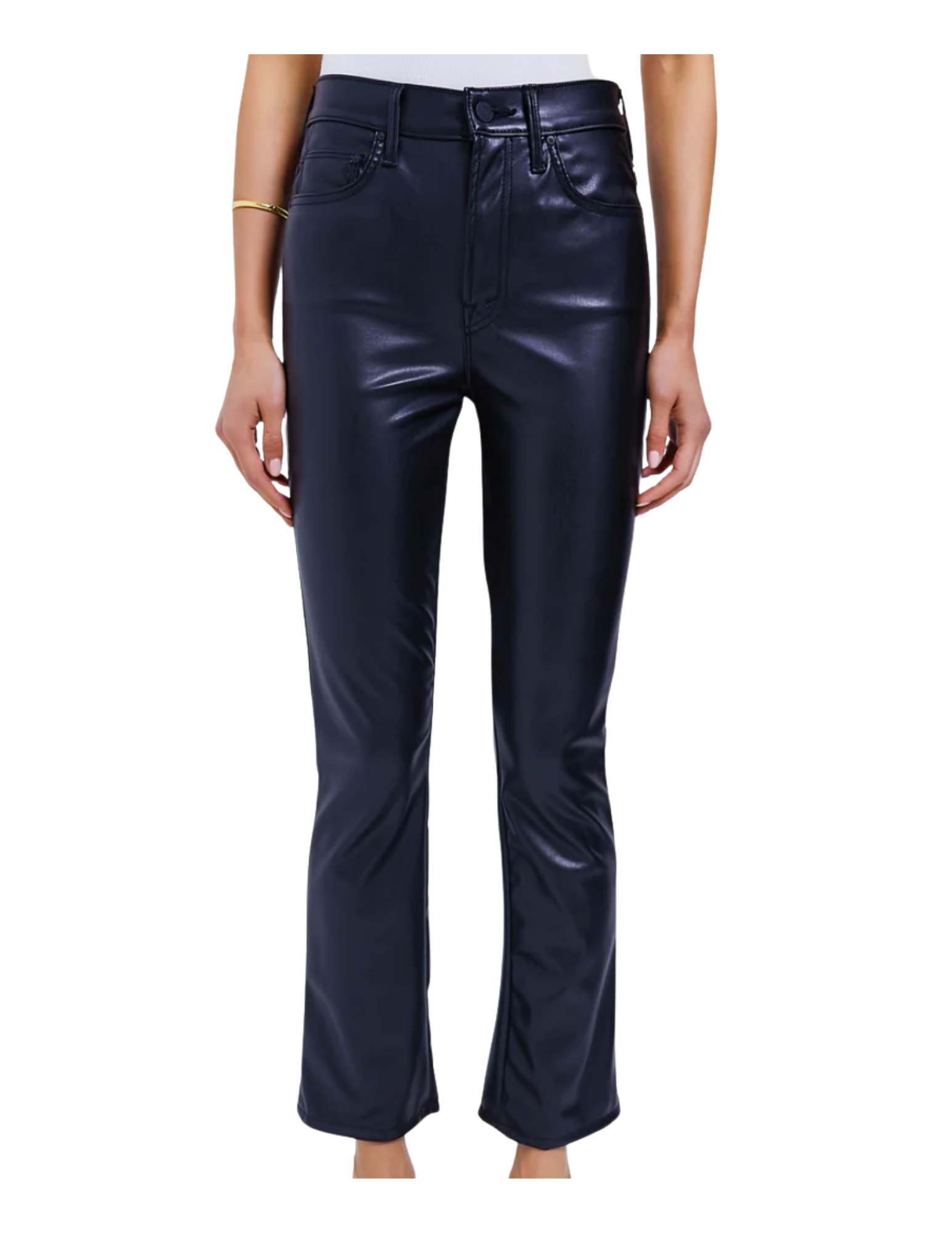 A person wearing black shiny faux leather pants with a white top and a gold bracelet on their left wrist.