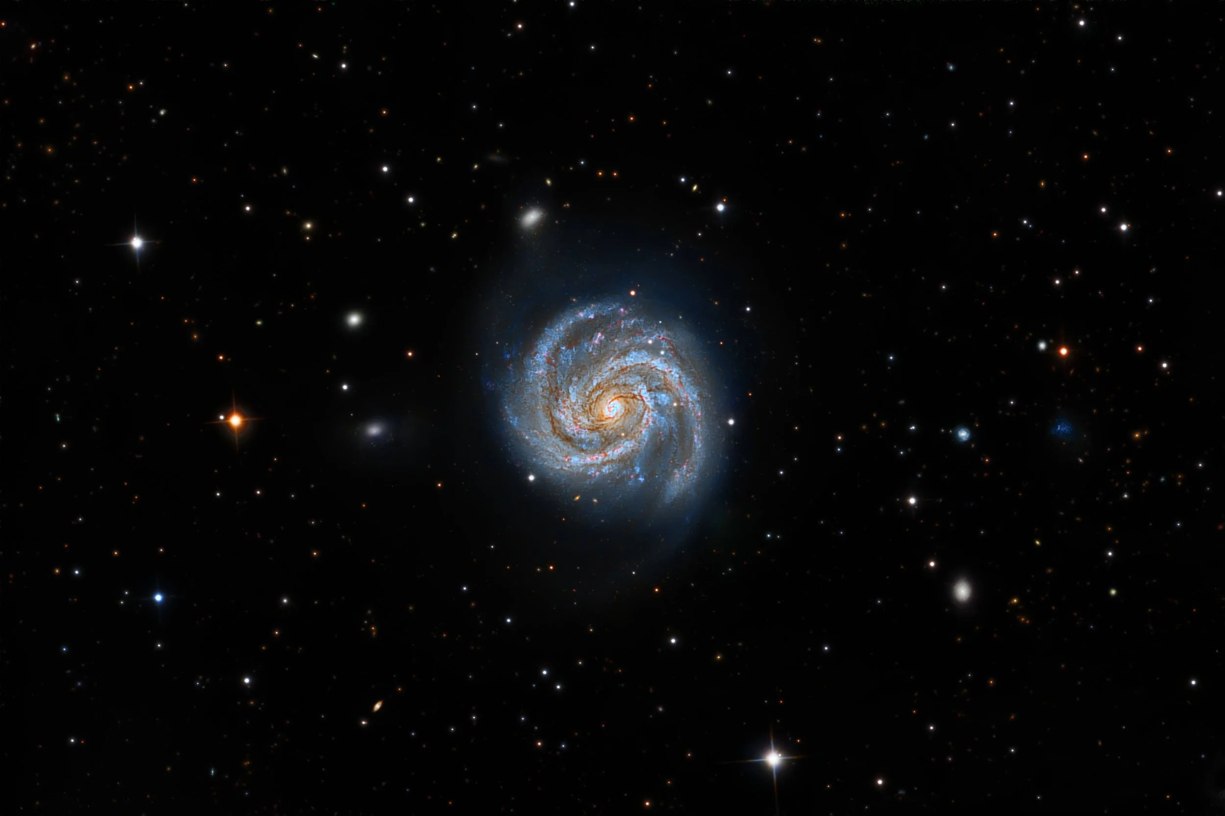 M100 is a classic grand-design spiral galaxy located about 55 million light-years away in the constellation Coma Berenices. Its two long, symmetric spiral arms are sharply defined and rich in blue star-forming regions, making it one of the most photo
