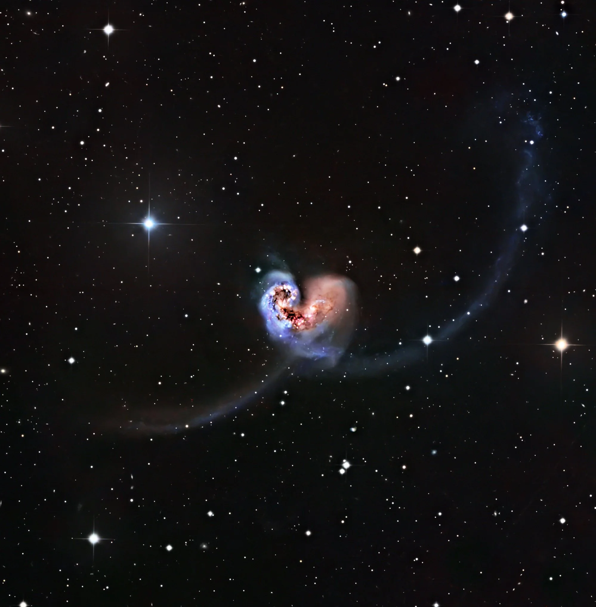 The Antennae Galaxies are a pair of interacting and merging spiral galaxies located approximately 45-70 million light-years away.

The galaxies get their distinctive name from the two long tidal tails, of stars, gas, and dust that have been flung out