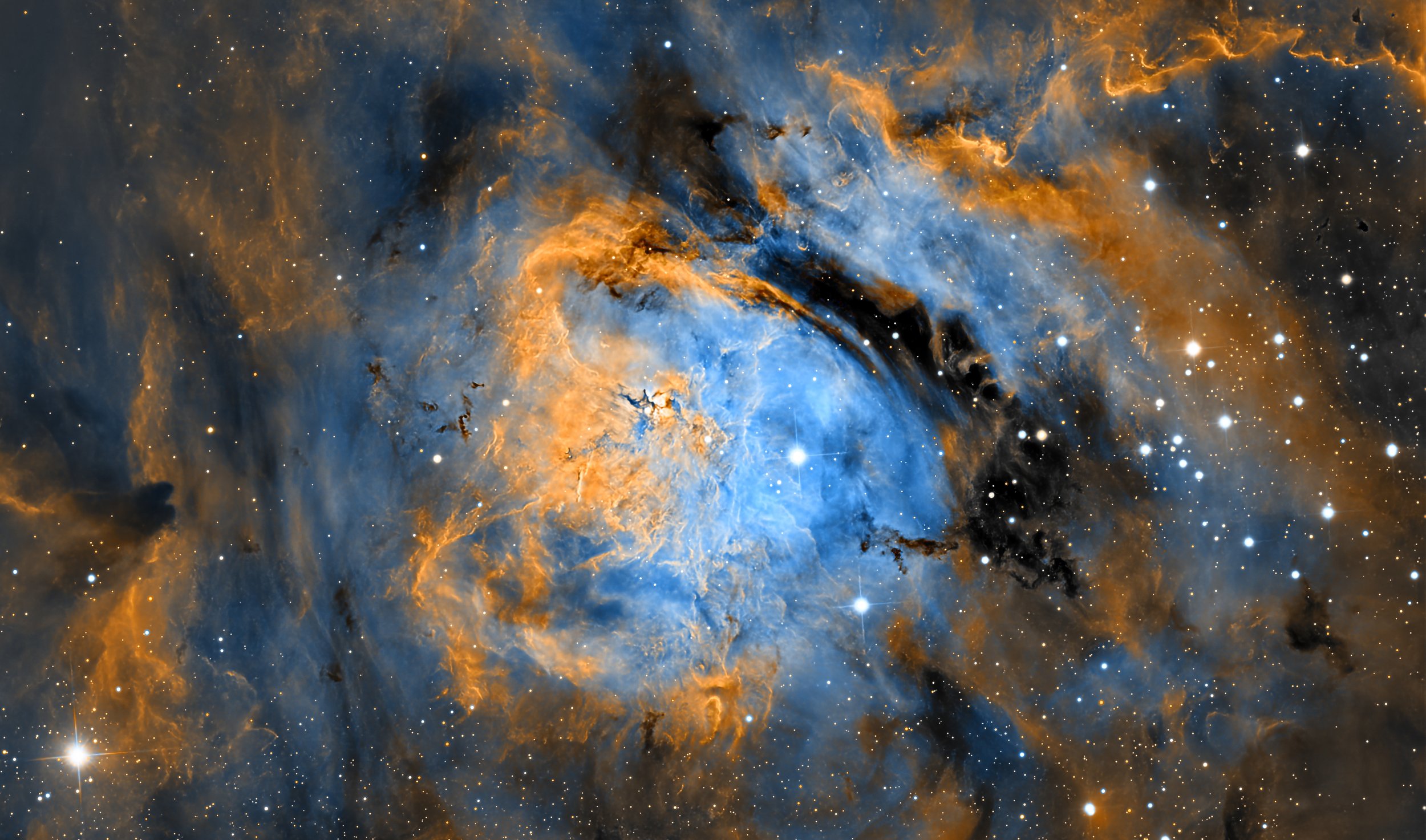 One of the Milky Way’s most famous and spectacular star-forming nebulae, M8 is located about 4,100 light-years away in the constellation Sagittarius. It’s a vast cloud of glowing hydrogen gas threaded with dark dust lanes, giving it a dramatic mix of