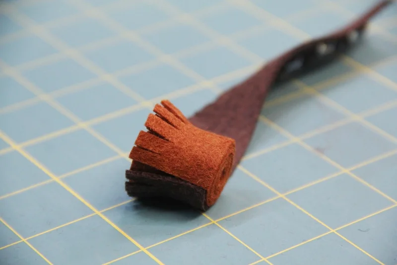 Start rolling dark brown strip around light