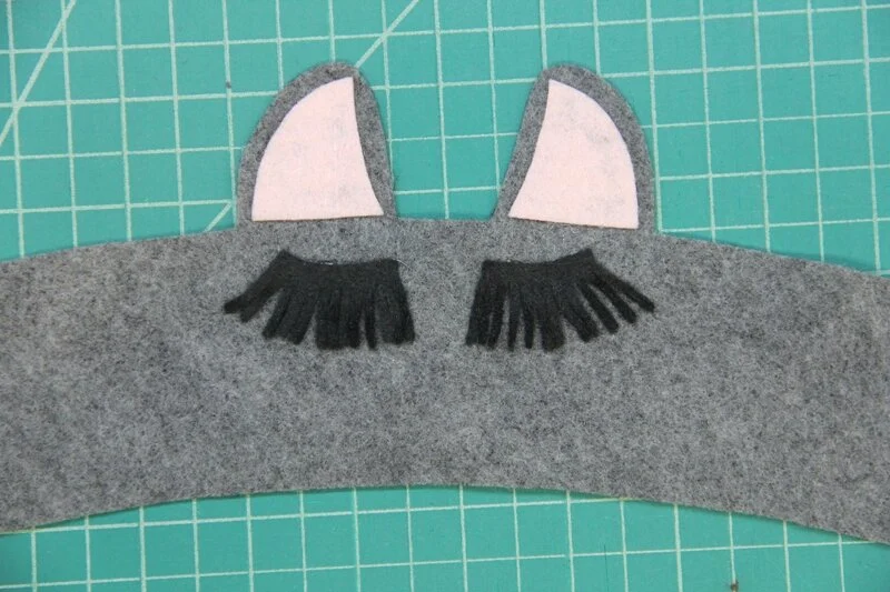 Second eyelash glued onto llama coffee cozy