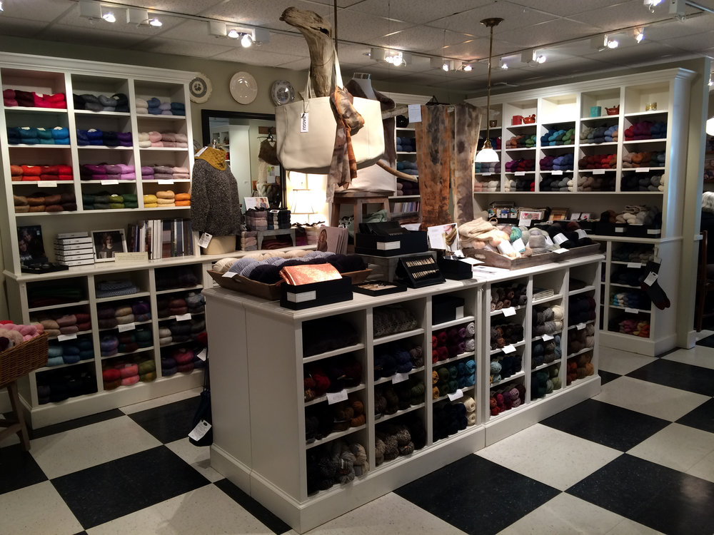  Each cubby is filled with skeins of yarn sorted by color and fiber. 