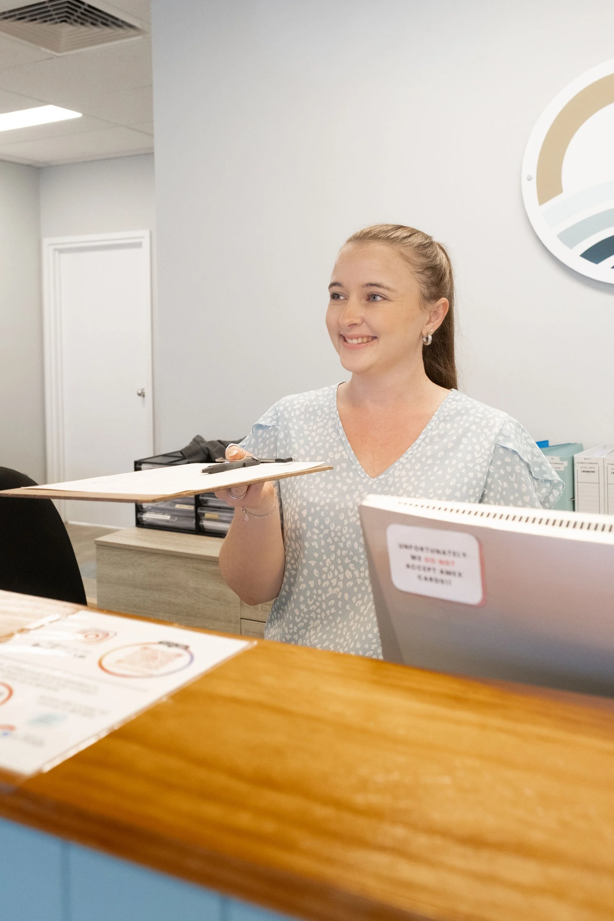 Friendly chiropractic assistant helping client to claim EPC, DVA, ICWA, Private Health or WorkCover
