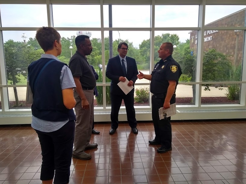 Lansing Chief of Police Dennis Murrin (right) speaks with Chicago Lawyers’ Committee Advocacy Director Aneel Chablani (center) and Lansing community leader Elvis Slaughter (left) after signing the final MOU.