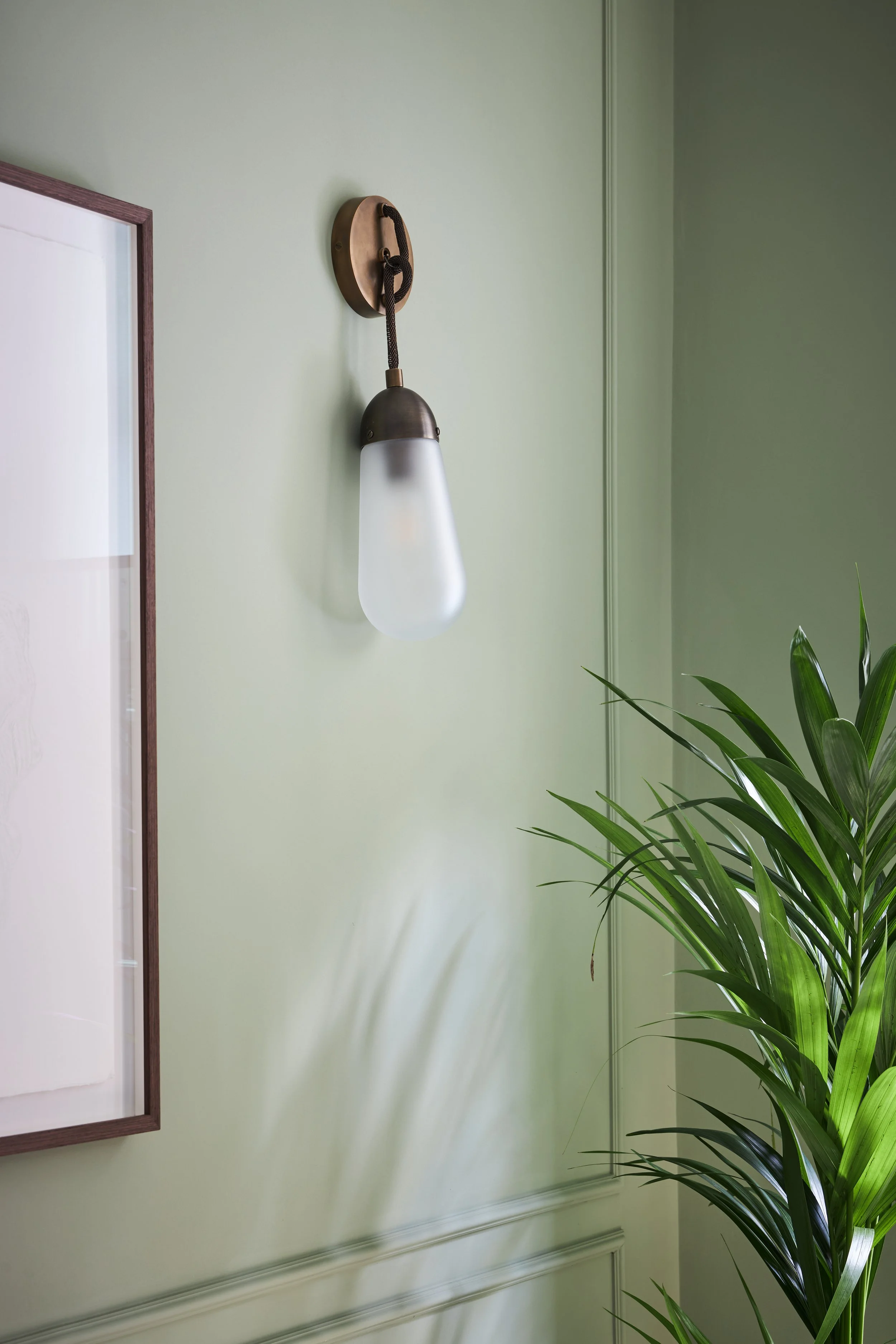 A close-up shot of the lighting by Apparatus against restful green walls by Little Greene.