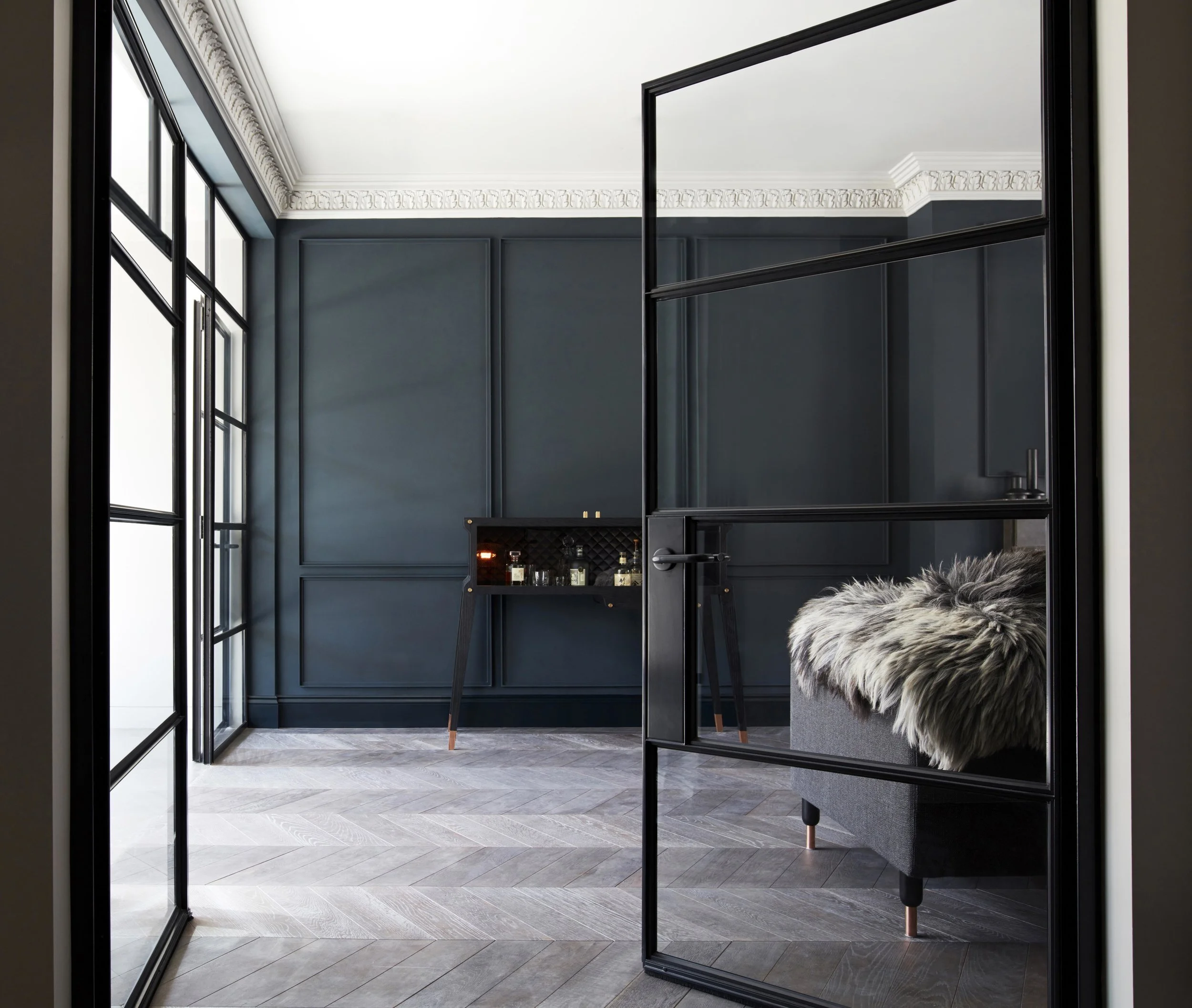 Buster + Punch whiskey bar in situ against a dark grey wall with period panelling, cornicing and steel glazing in this Victorian terrace.