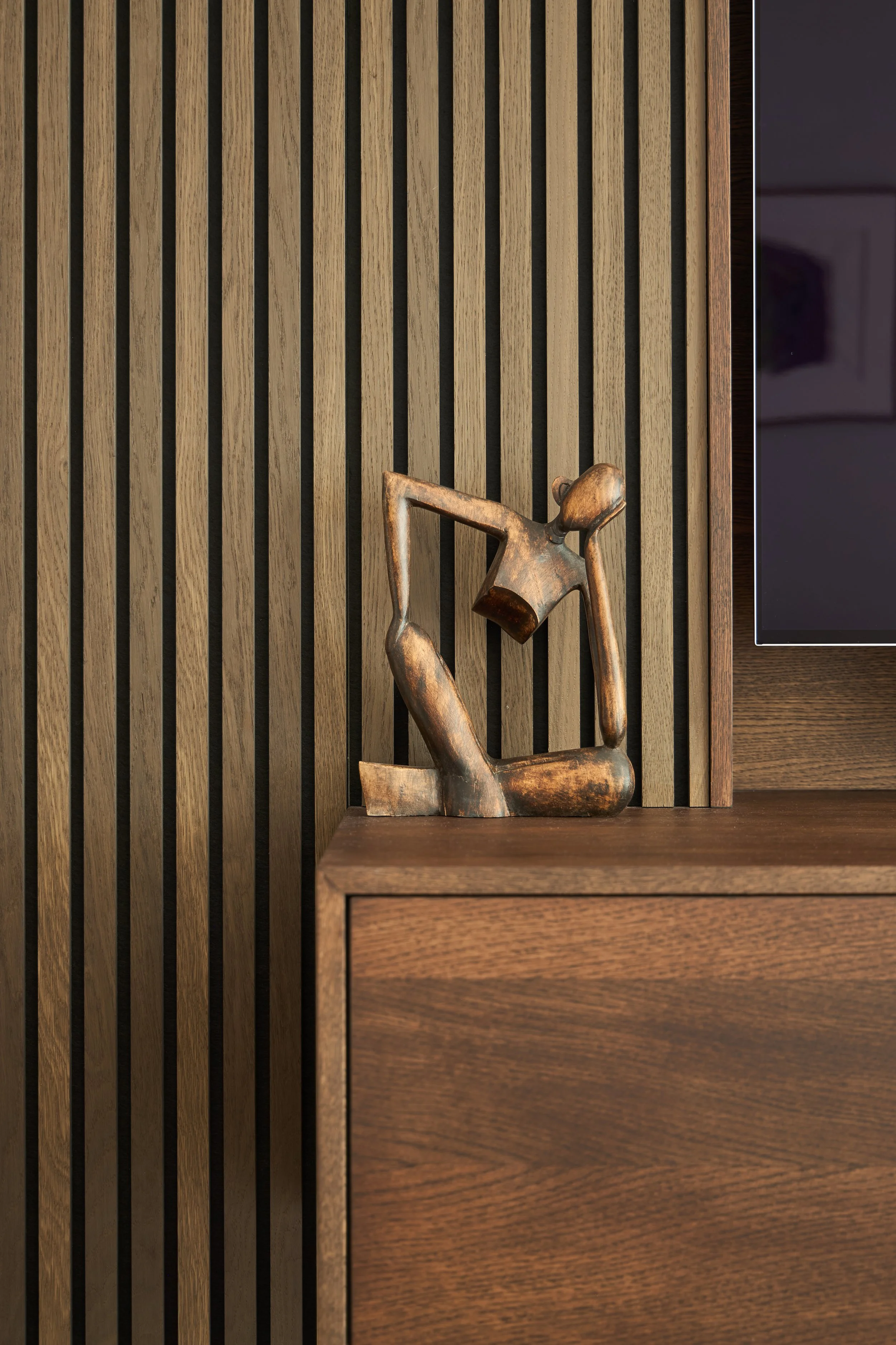 Bespoke walnut slatted panelling was installed into the new family TV room to aid acoustics, along with a matching floating credenza.