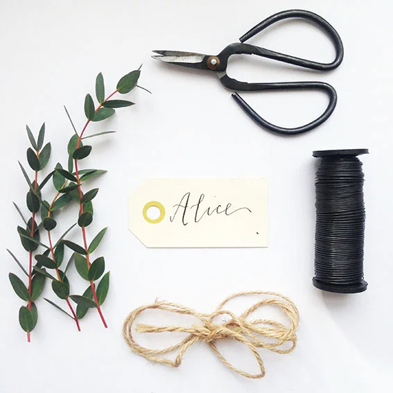 Materials: Eucalyptus, wire, sharp scissors, twine or ribbon, name tags (These hand lettered ones are available to buy from us with each name hand written, just pop over here . (quantities dependant on how many wreaths you are making)
