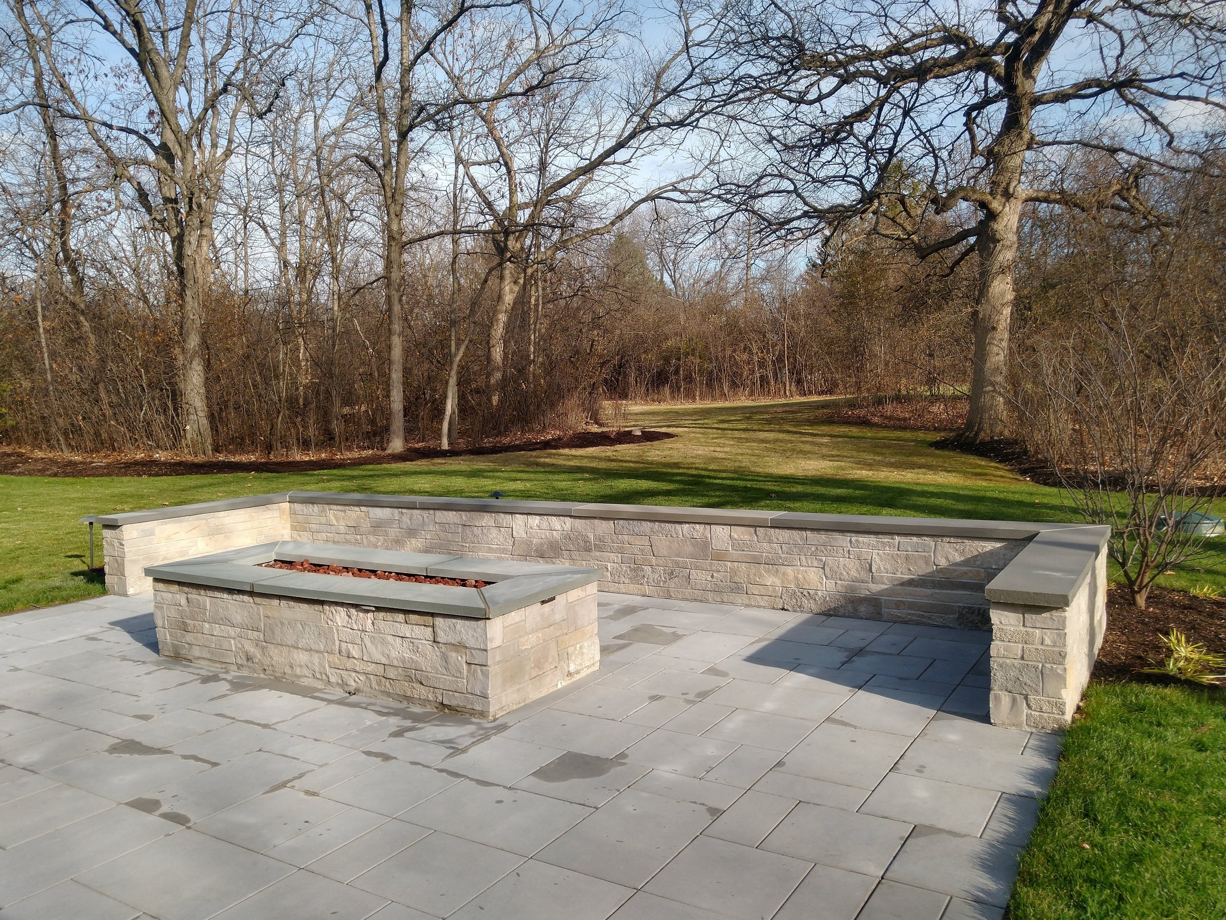 natural stone seatwall and gas fire pit bluestone tops.jpg