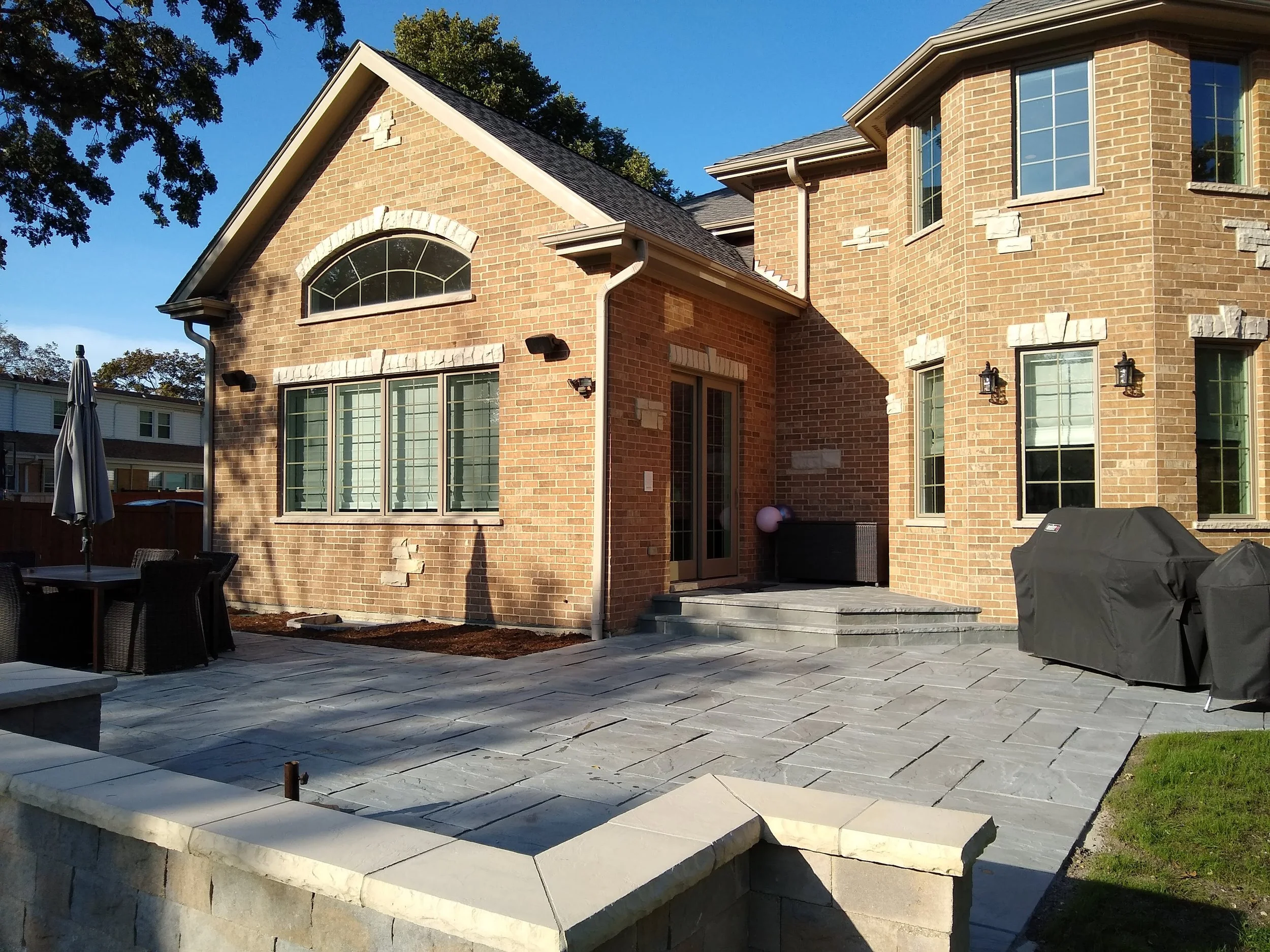 complete, cohesive outdoor living space — patio, seat wall, fire pit, steps, and gas line