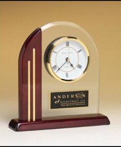 Arch Table Clock Arch clock with glass upright and rosewood piano-finish post and base. Price of $103.00 does not include engraving. Engraving is the greater of $24 or 30¢ per character. Overall size is 7½” x 7-7/8″ x 2″. Lifetime guaranteed movement .