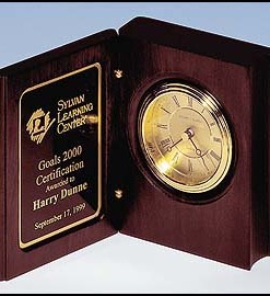 Book Clock Rosewood stained clock in the shape of a book. Diamond spun dial and 3 hand movement that is guaranteed for life. Price of $87.50 does not include engraving. Engraving is the greater of $24 or 30¢ per character. Overall size is 5 3/8″ x 4¼” x 1 7/8″.