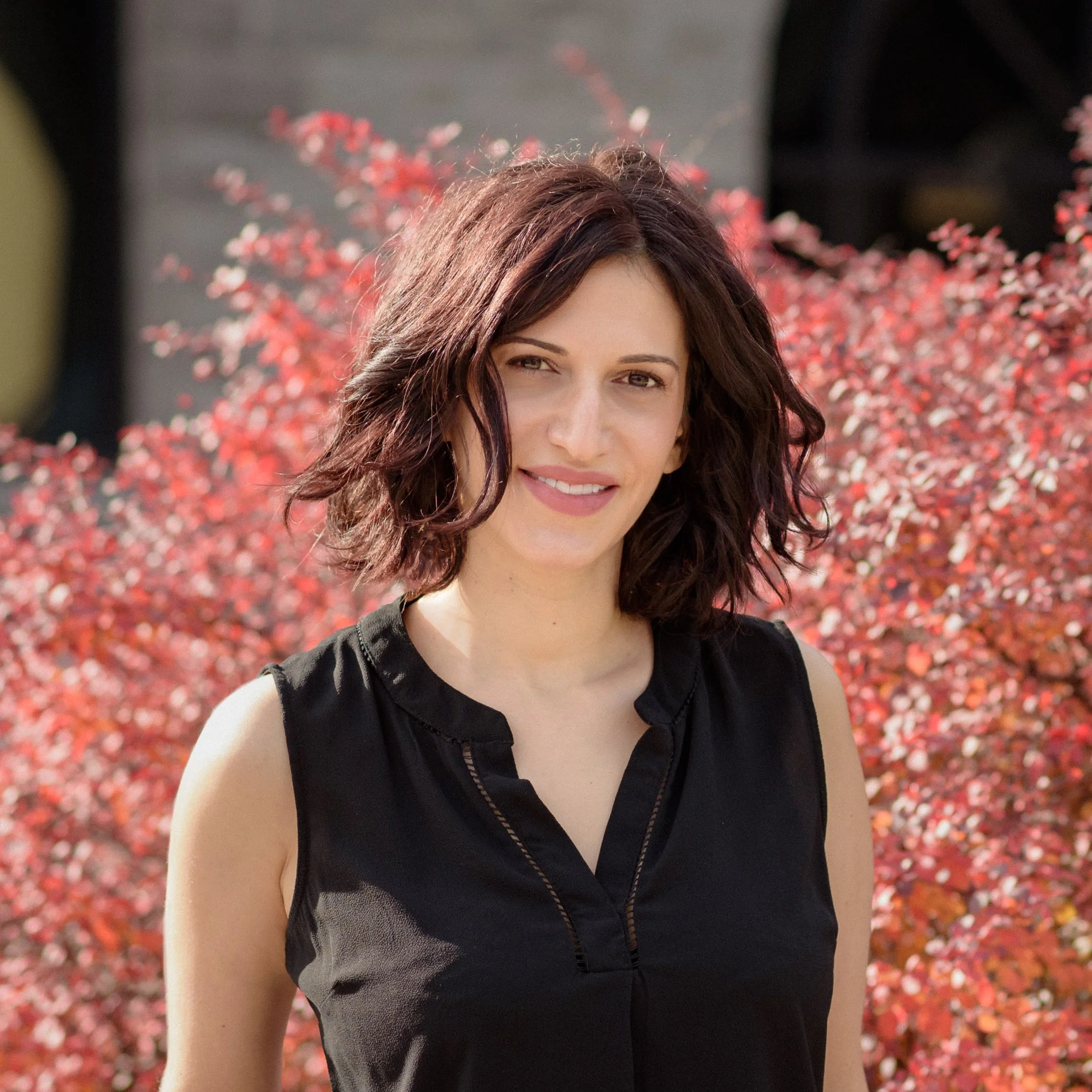 Michele standing in front of some bushes.