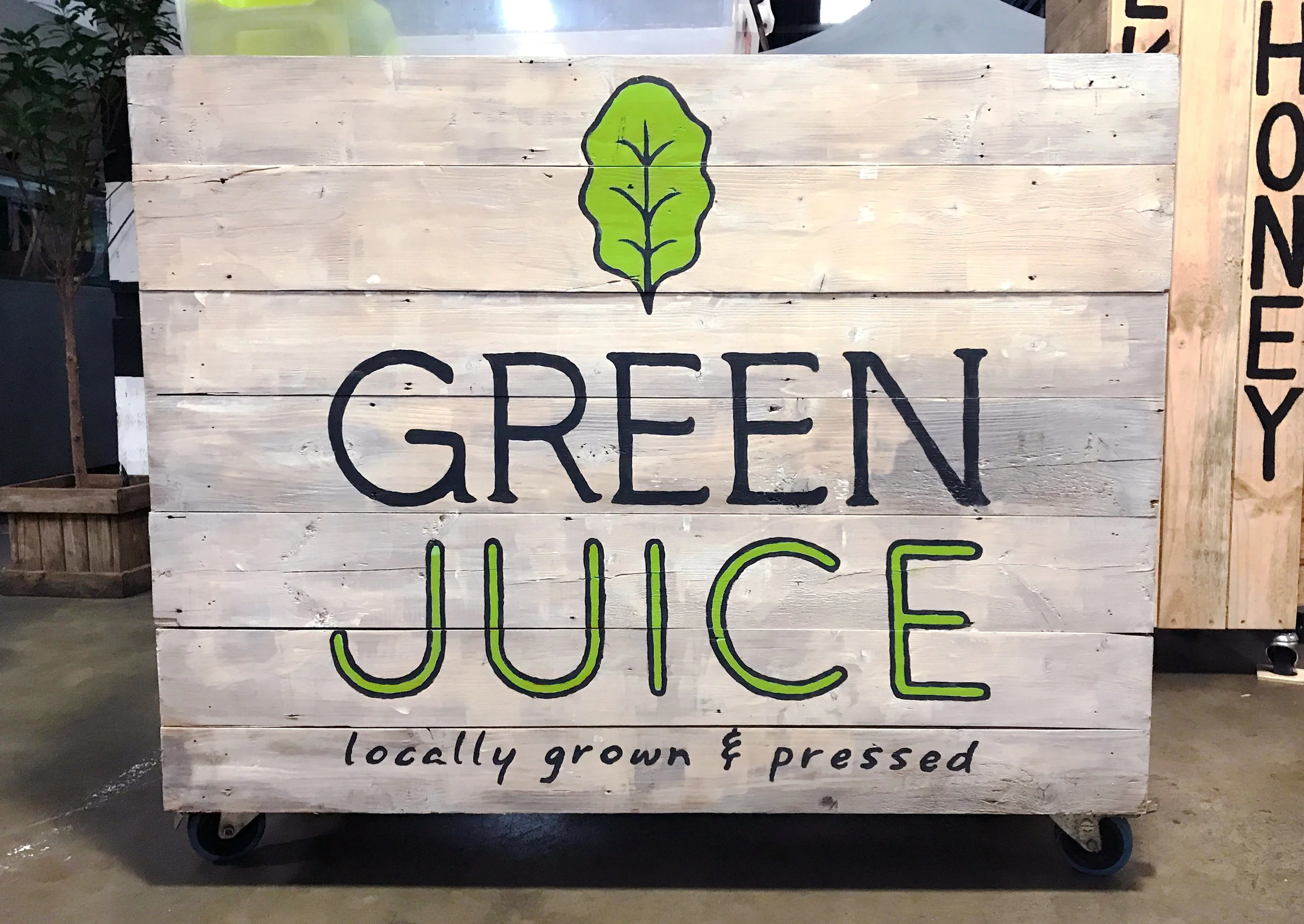 Hand-painted on one of the Green Juice market stall facades. The logo was designed to work well with the rustic feel, so the project & paint method worked perfectly. ^_^