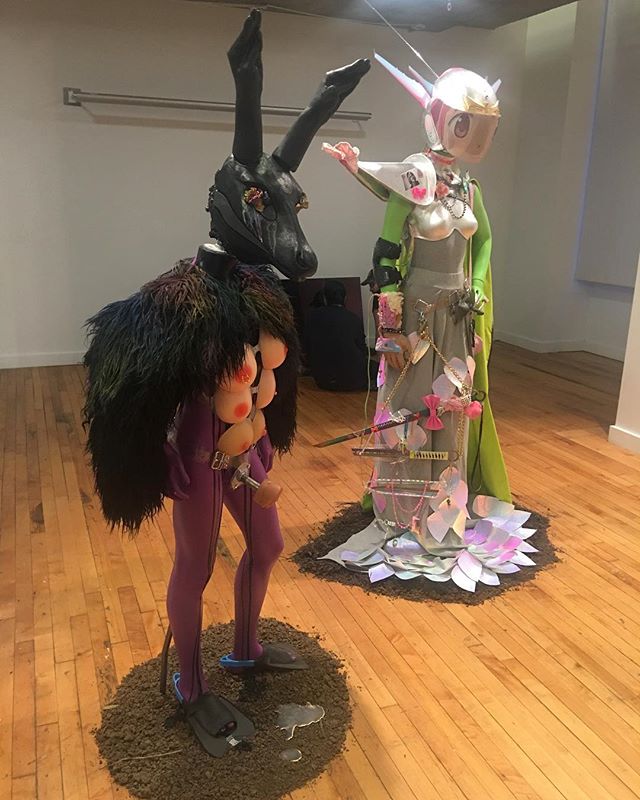 2 of 3 transfuturist costumes, a narrative about the nefariousness of soy inside a virtual environment, and a small lewd shrine to transfemme resilience by Tabitha Nikolai.