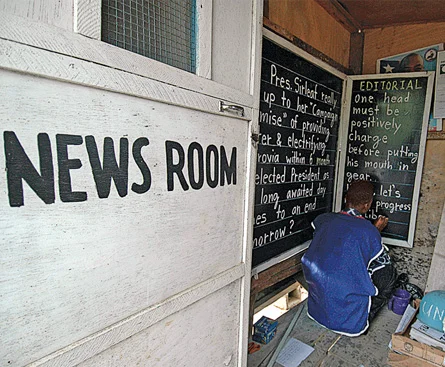 Alfred Sirleaf writes the day’s major headlines on a blackboard for Liberians who cannot afford newspapers.