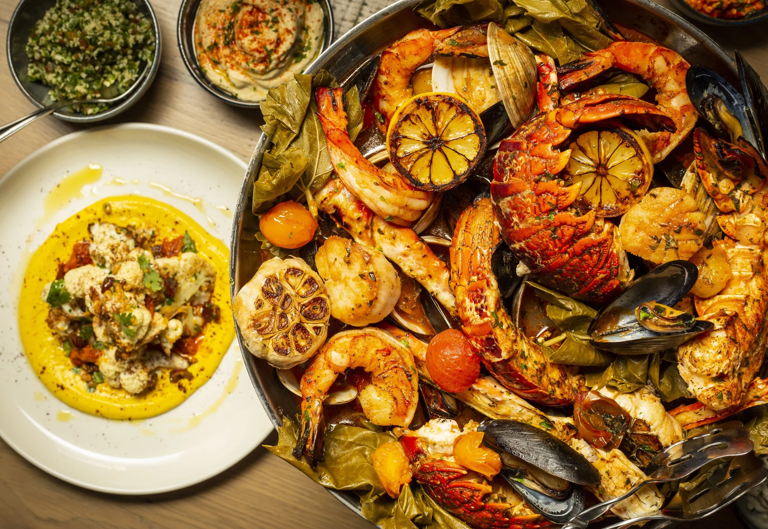 Open-fire roasted shellfish platter at Del Mar West Palm Beach — South African lobster tails, scallops, prawns, clams and mussels
