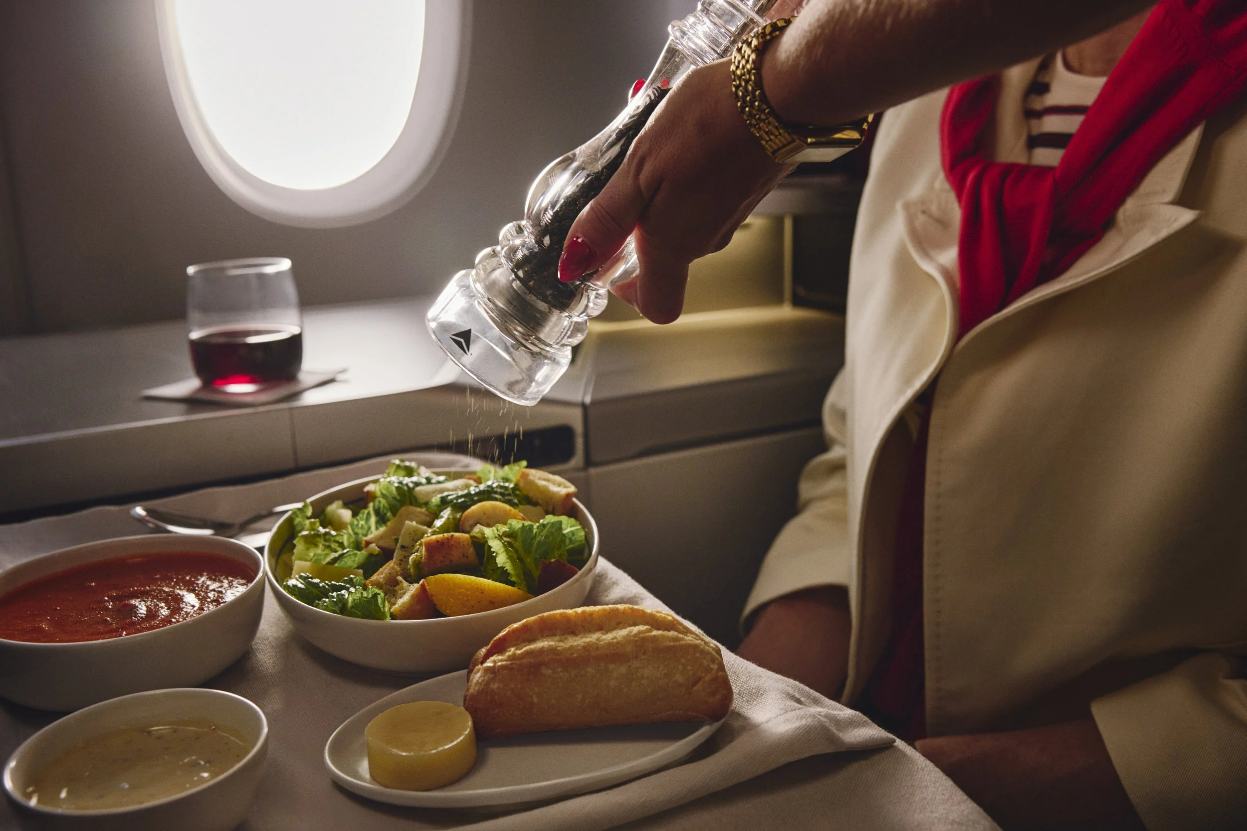 Fresh cracked pepper service over a salad in the reimagined Delta One business-class cabin