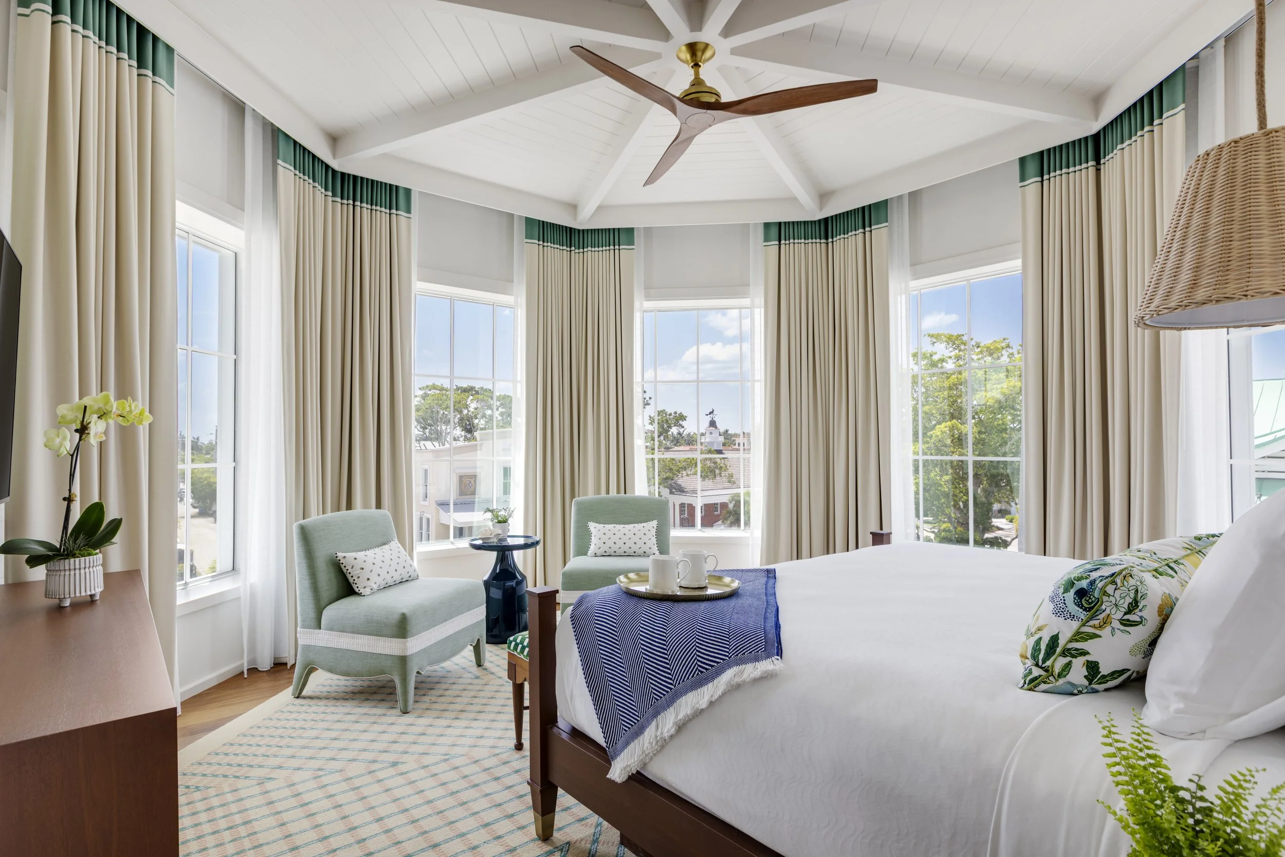 A guest room at Olde Naples Hotel with vintage patterns and coastal tones