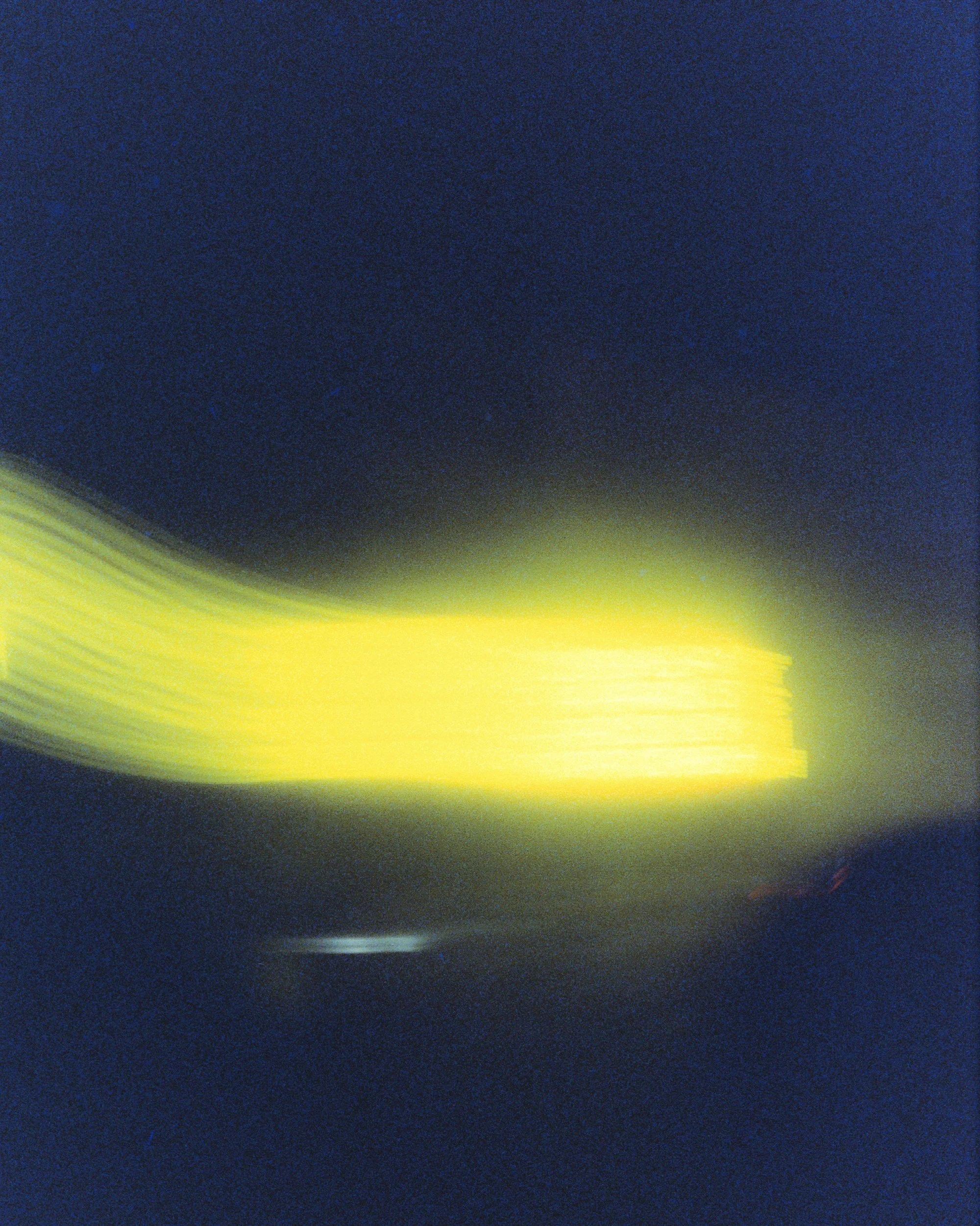 Abstract photo with blurry streaks of yellow and green against a dark blue background.