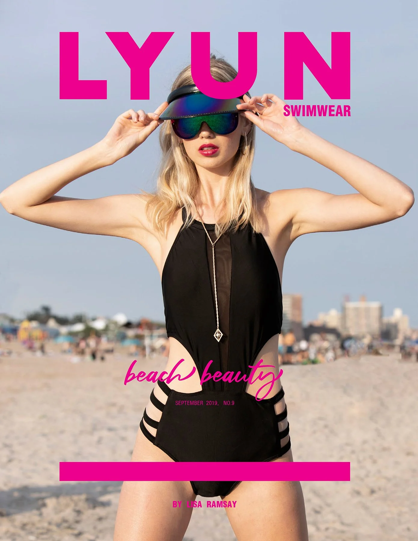 Cover of a magazine titled 'Lyun Swimwear', featuring a woman in black swimwear with striped sides, standing on a beach with a cityscape in the background. She is adjusting her reflective visor sunglasses, has blonde hair, red lipstick, and is wearin