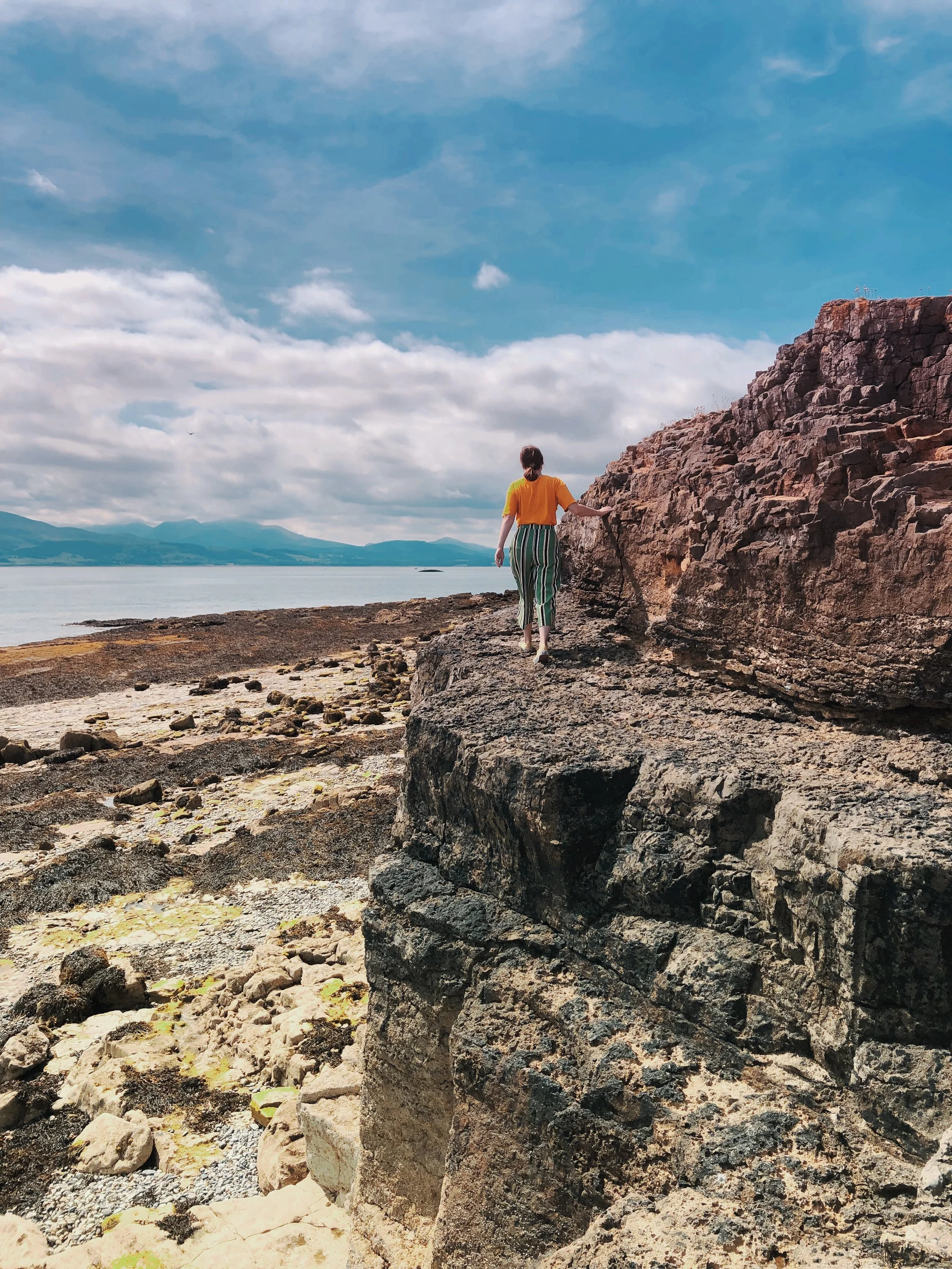 Samantha climbing the cliffs around Penmon Point