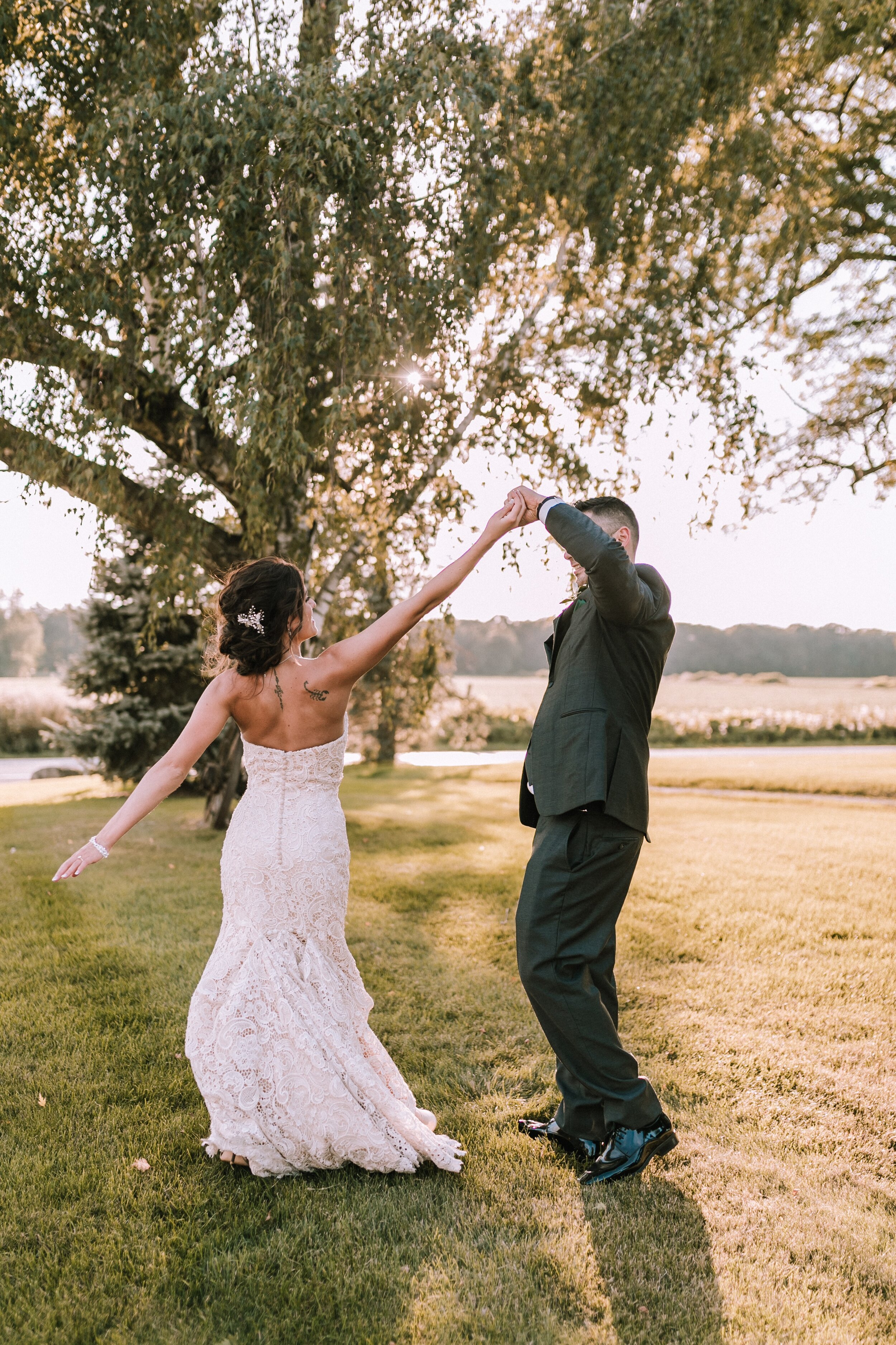 groom twirling bride in lace bridal gown