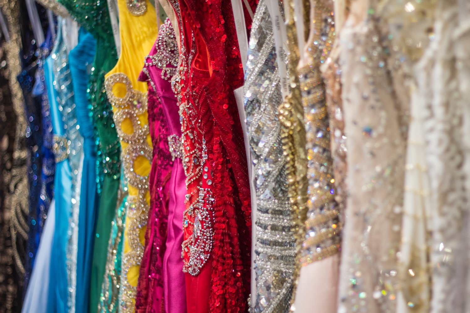 In store photo of prom dress selection, multiple circular racks of dresses.