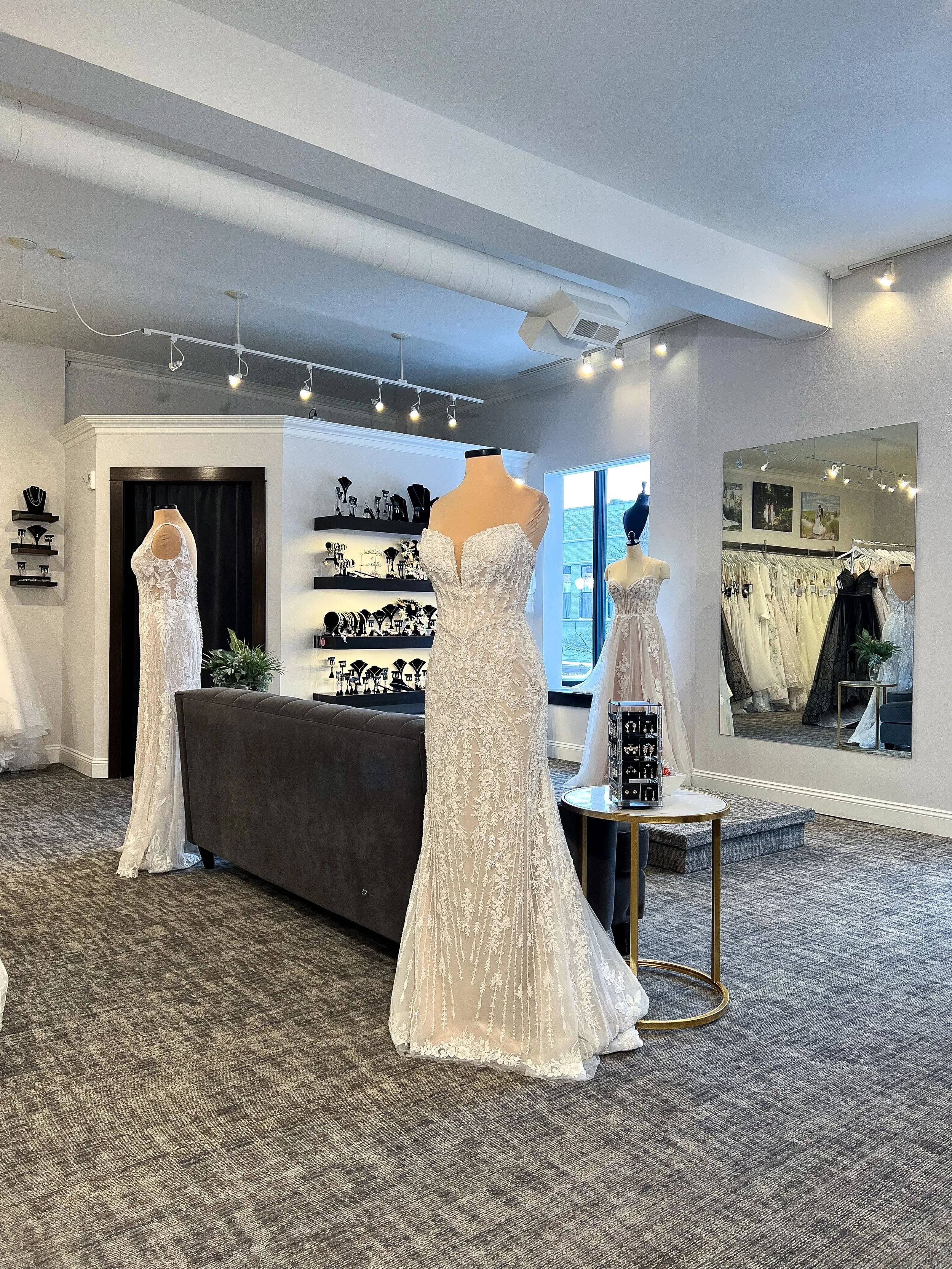 Consultant helping a bride as she wedding dress shops and tries on a dress.