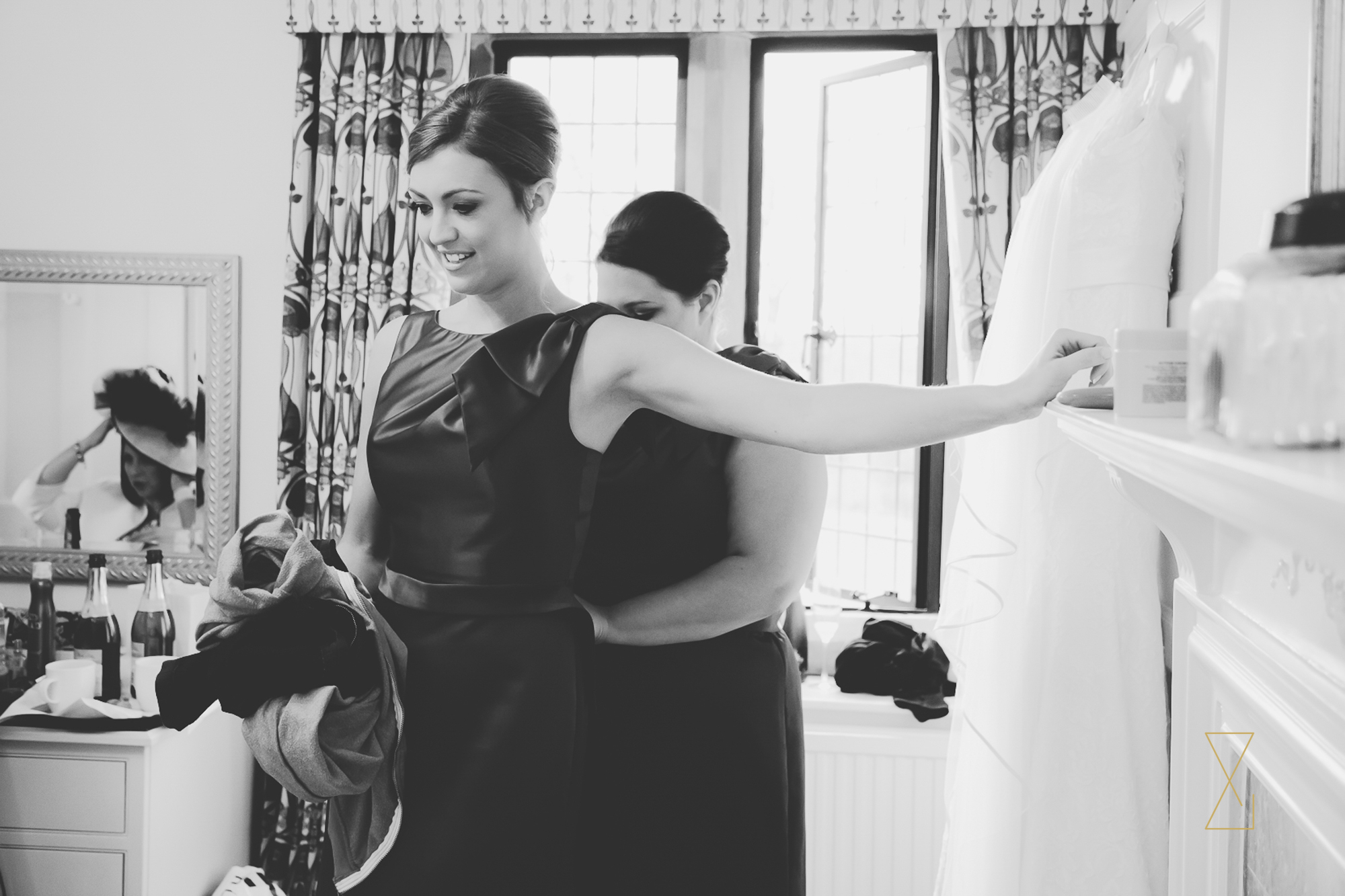Bridesmaid helping each other put on their dresses at Colshaw Hall Cheshire, Evans & Evans wedding photography