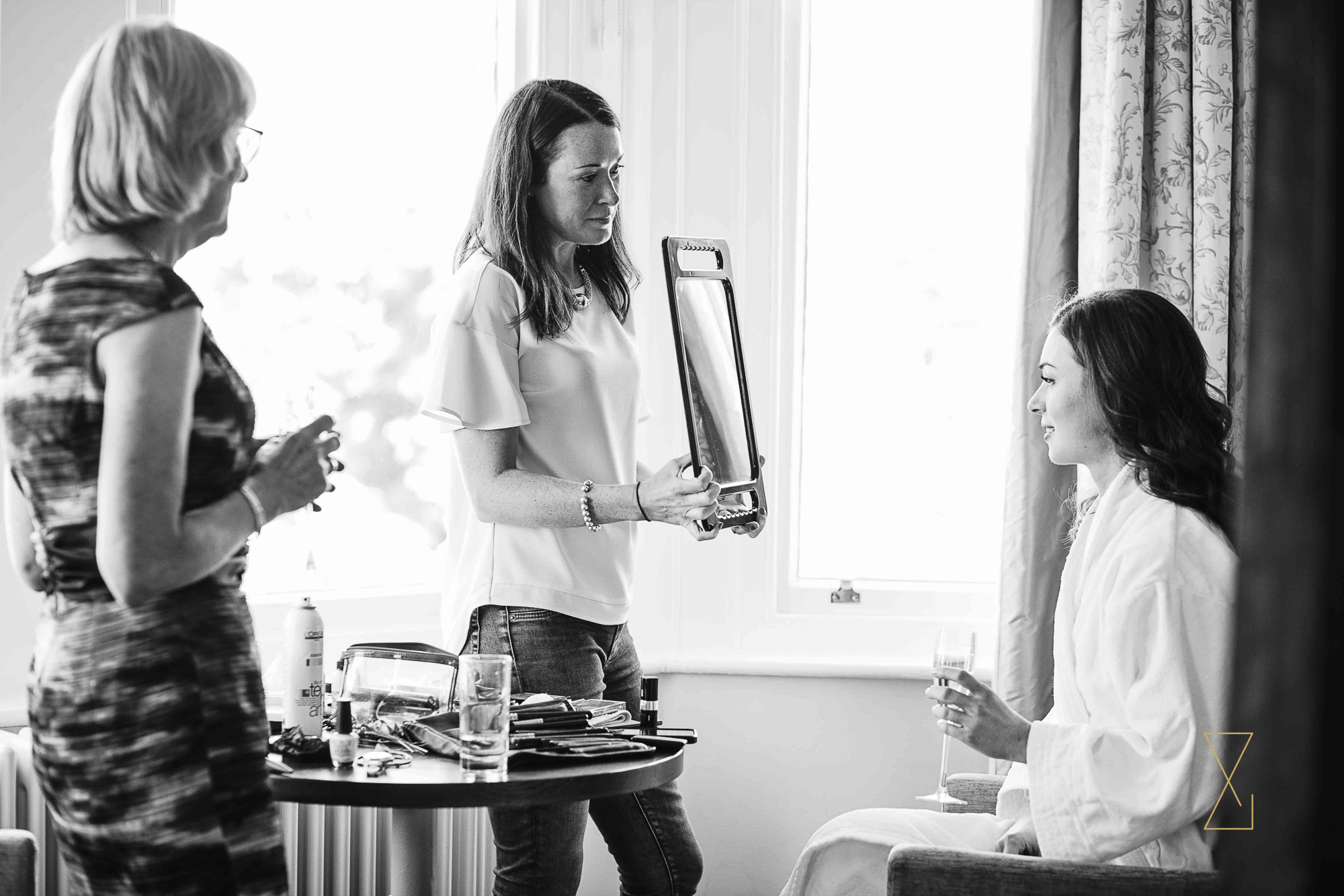 Bride checks her reflection at Laura Ashley Belsfield, Evans & Evans wedding photography