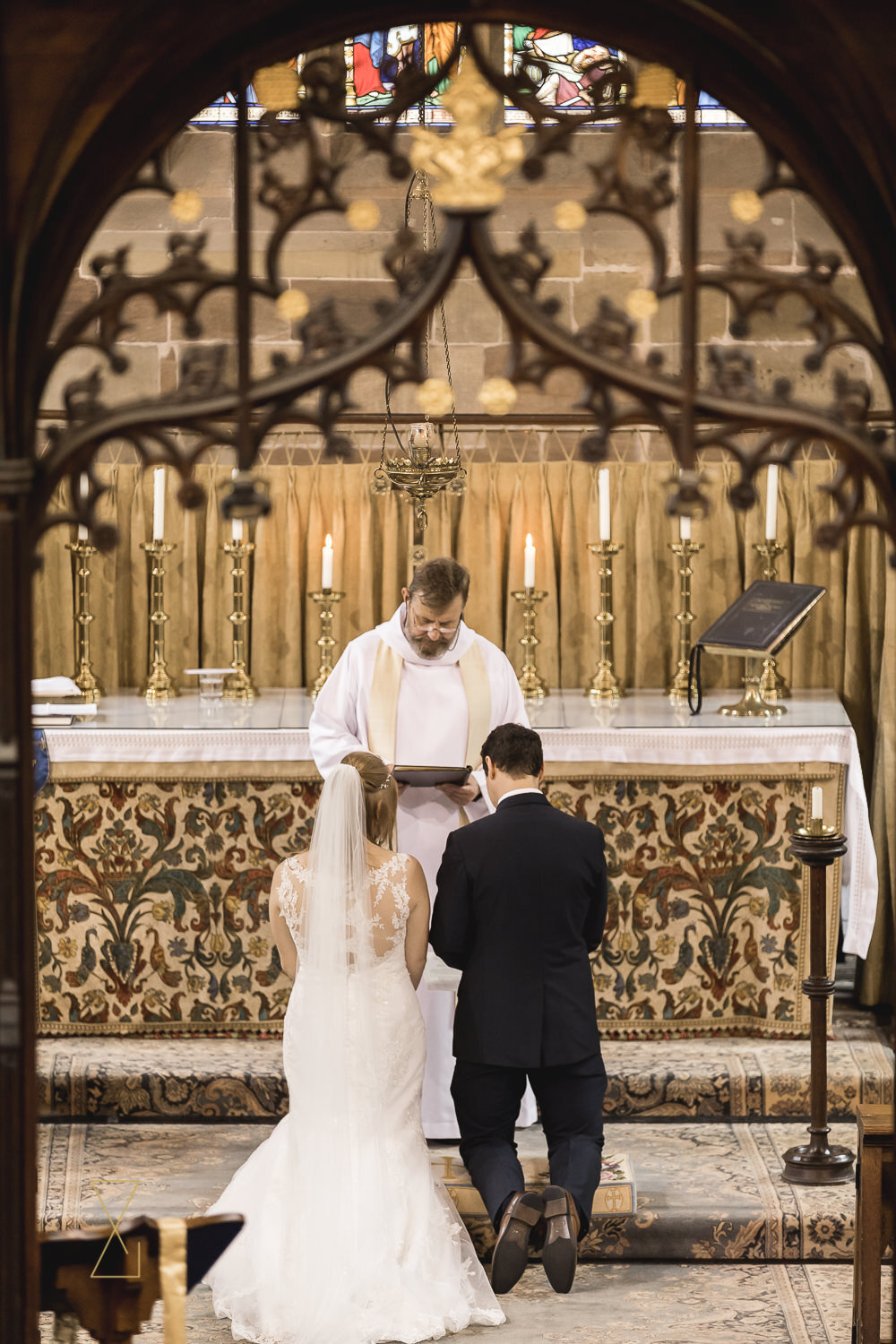 Bride-and-groom-kneeling-at-altar-Gawsworth-church