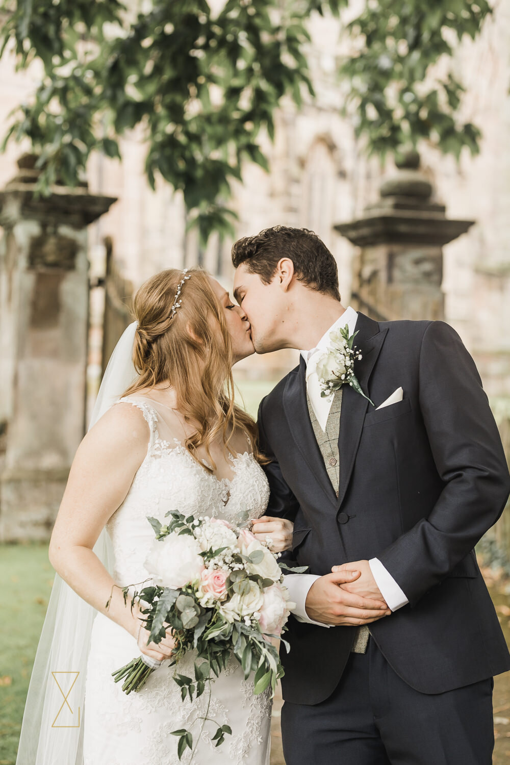 Bride-and-groom-kiss-outside-Gawsworth-church