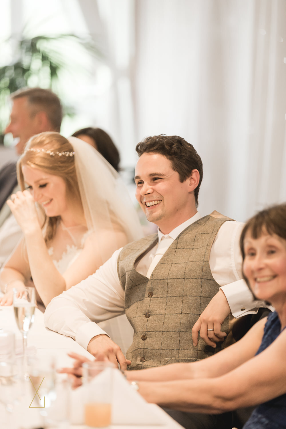 Bride-and-groom-laughing-during-wedding-speeches